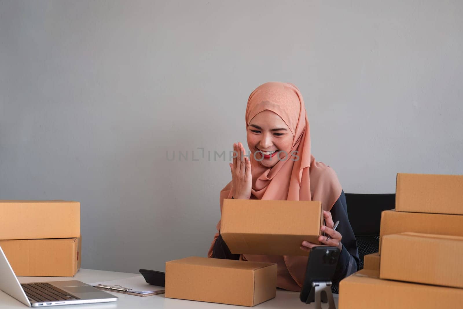 Beautiful Muslim woman selling online at home, business owner, business start up small business concepts by wichayada