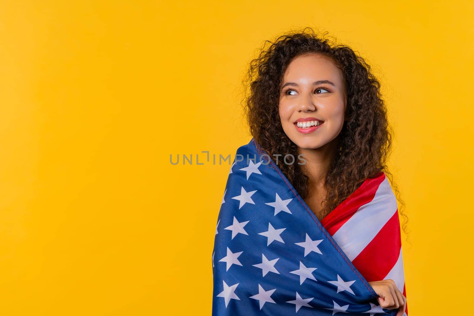Happy woman with national USA flag on yellow. American patriot 4th of July, copy by kristina_kokhanova