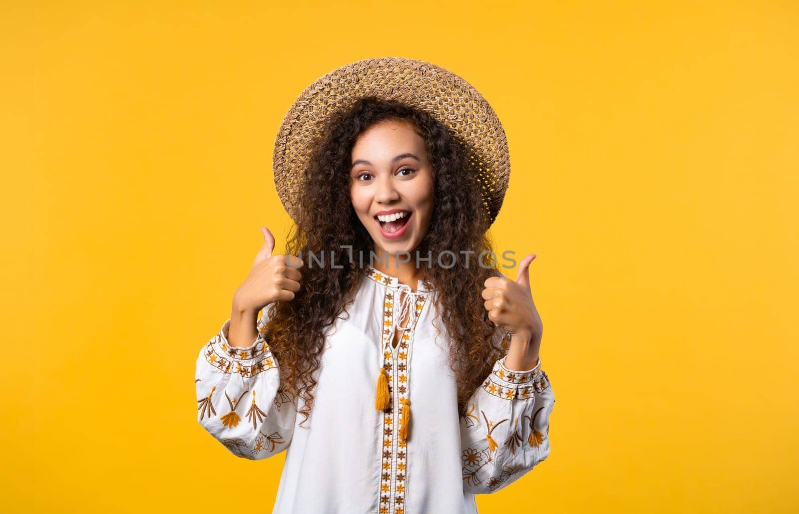 Positive ukrainian woman makes like hand sign, thumbs up gesture. Happy girl, correct perfect choice, great deal, yellow background. Positive lady smiles to camera, approval, trust concept.