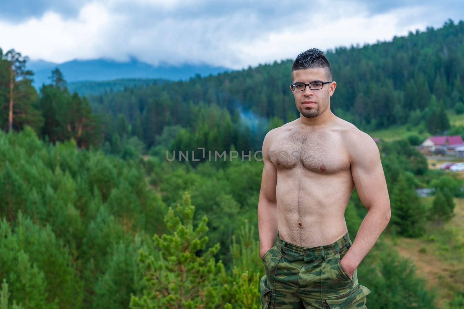 Handsome athletic Arab guy without a T-shirt on the background of the beautiful nature of the South Urals. by DovidPro