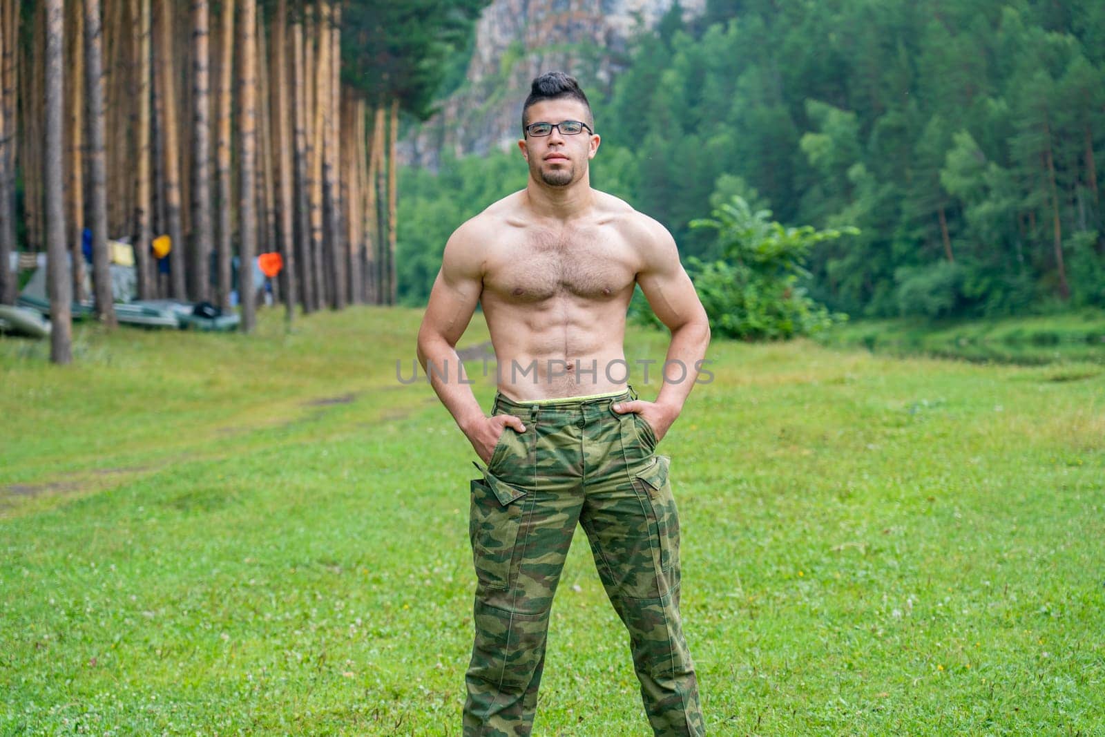 Handsome athletic Arab guy without a T-shirt on the background of the beautiful nature of the South Urals. by DovidPro