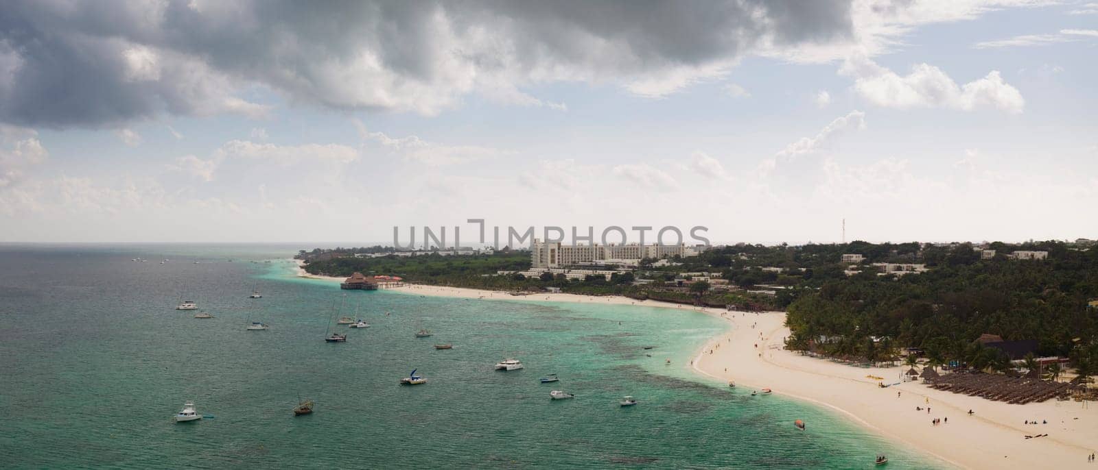 awesome aerial shot of shoreline and turquoise ocean in zanzibar at cloudy day, tanzania.