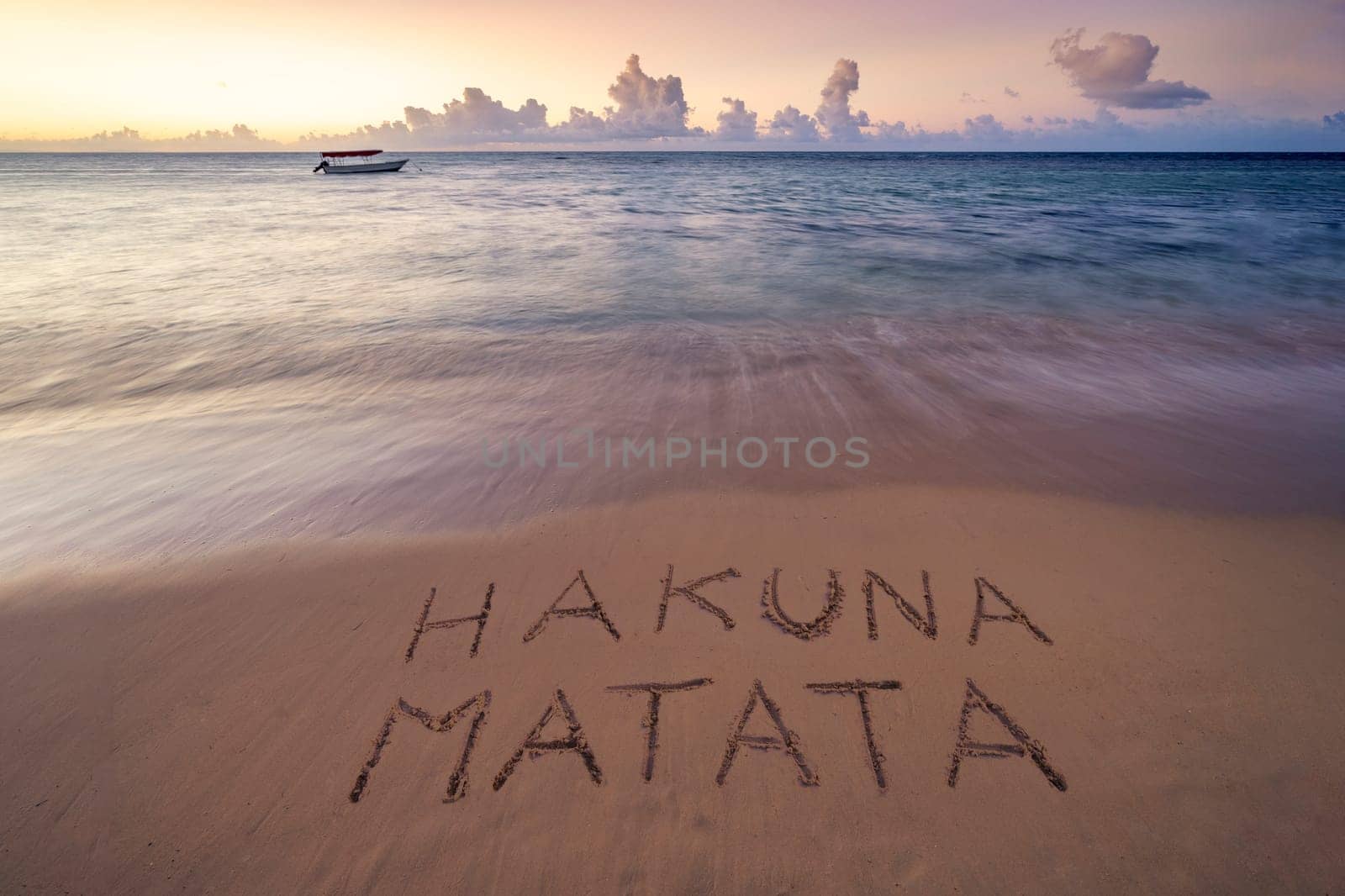 Handwritten Hakuna Matata on sandy beach at sunset african beach by Robertobinetti70