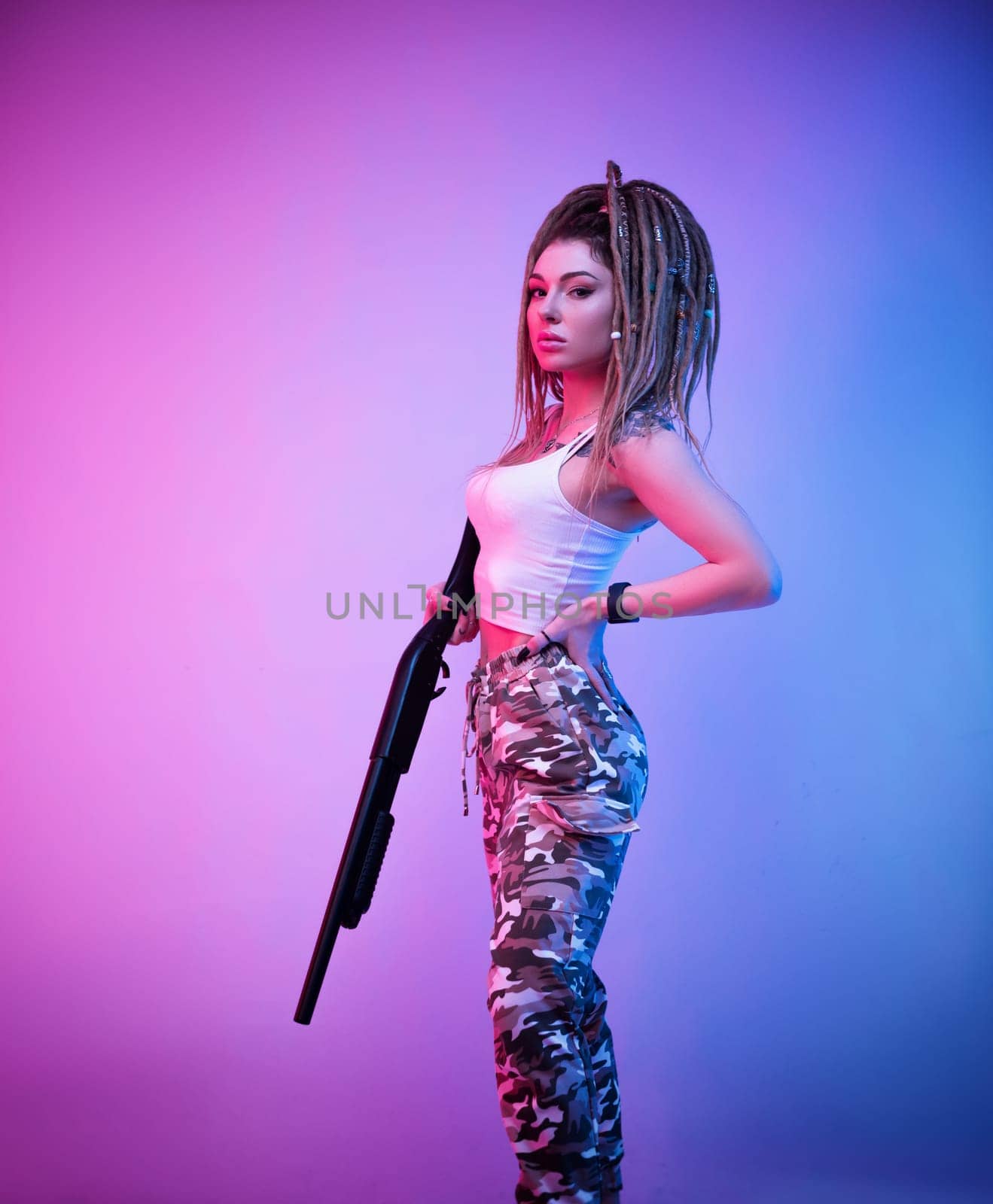 a cheeky girl with braided dreadlocks on her head in neon light with an gun in neon light