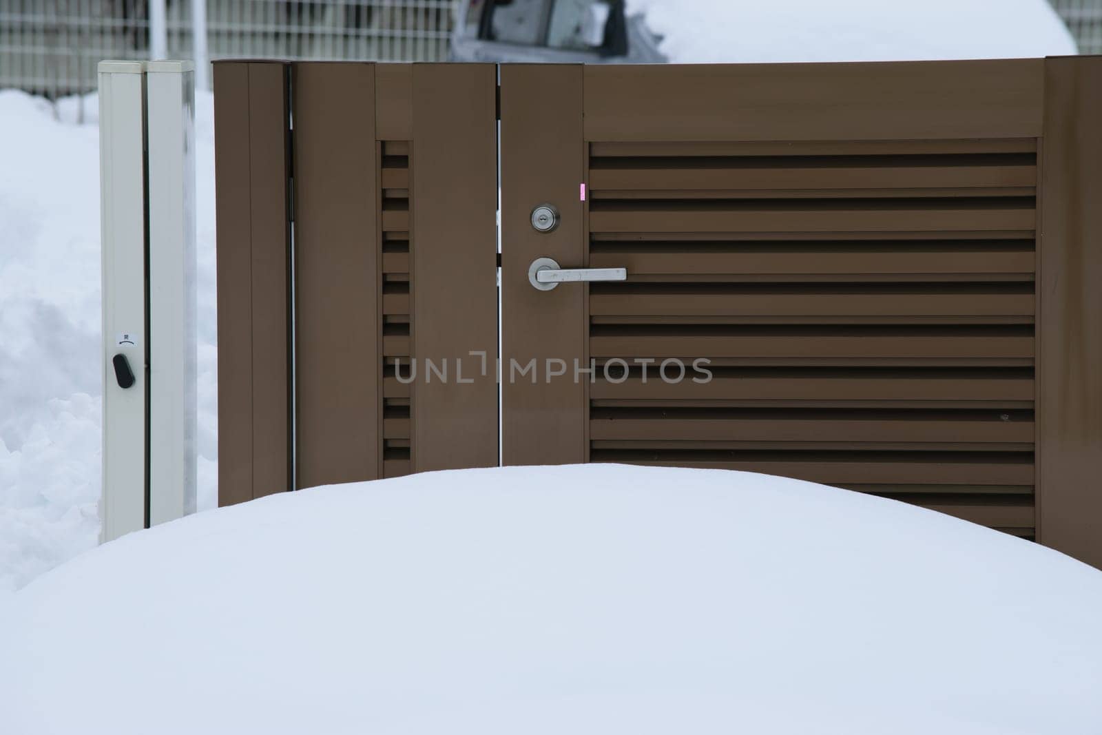 A brown gate with snow in front of it by jameshumble