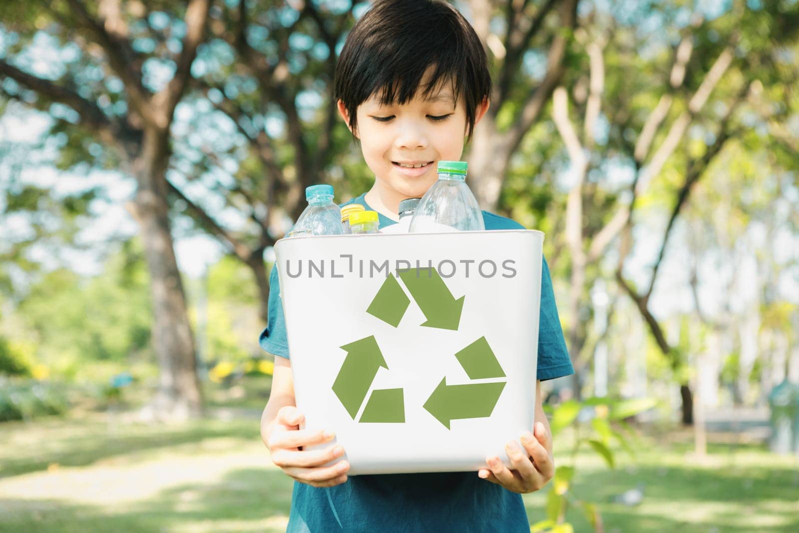 Cheerful young asian boy holding recycle symbol. Gyre by biancoblue