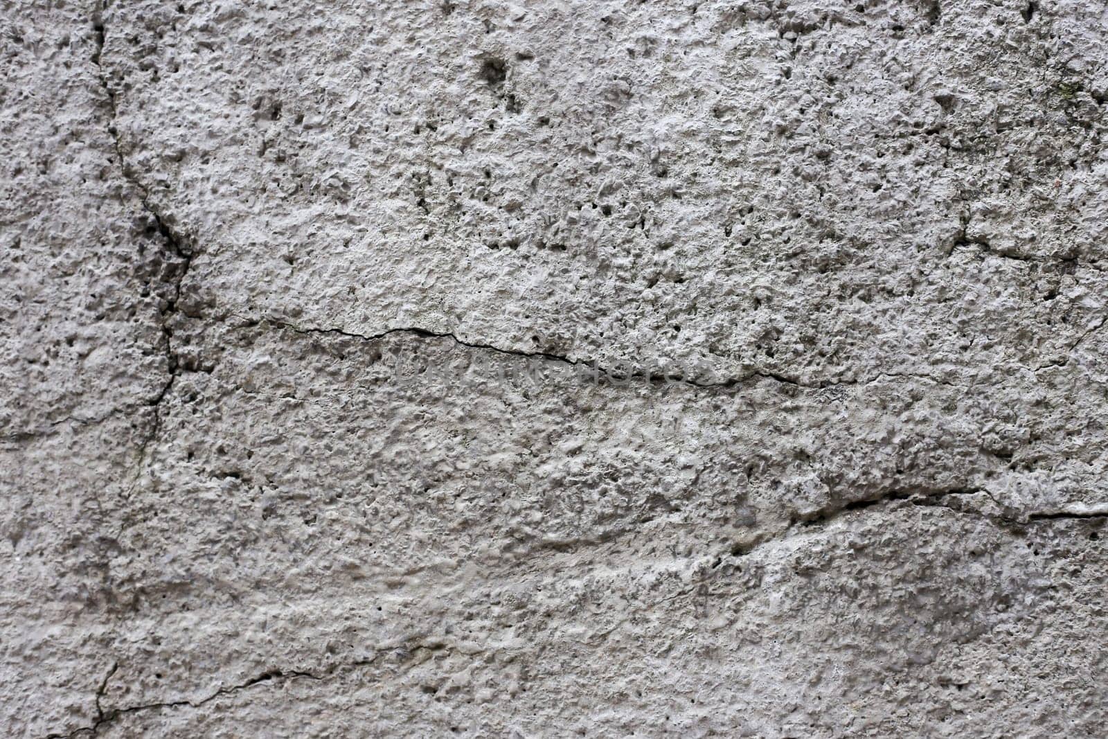 Old gray cracked stucco on the wall.