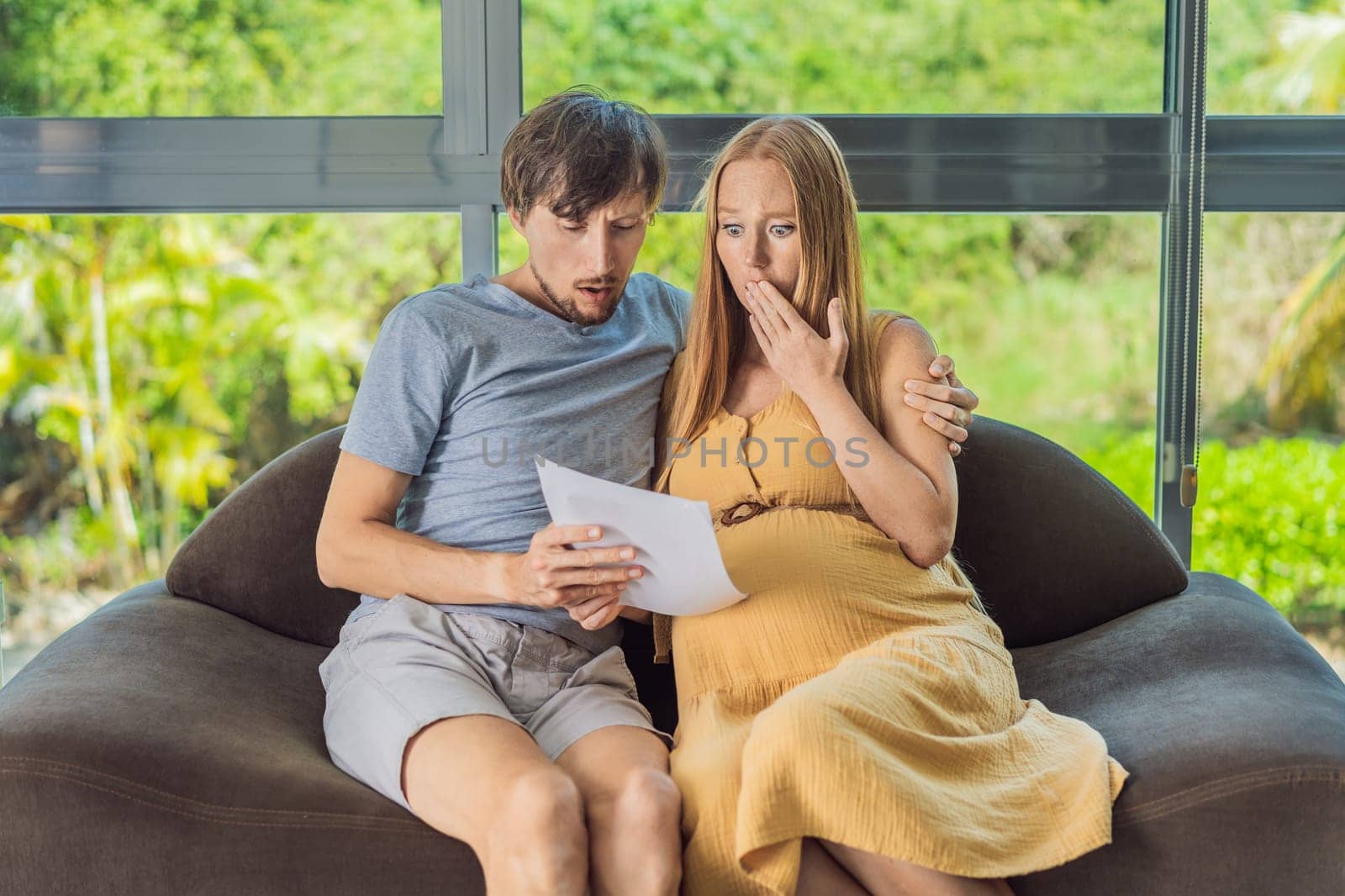 Cost of Pregnancy And Family Budgeting Concept. Young couple expecting baby, planning budget and counting spends at home by galitskaya