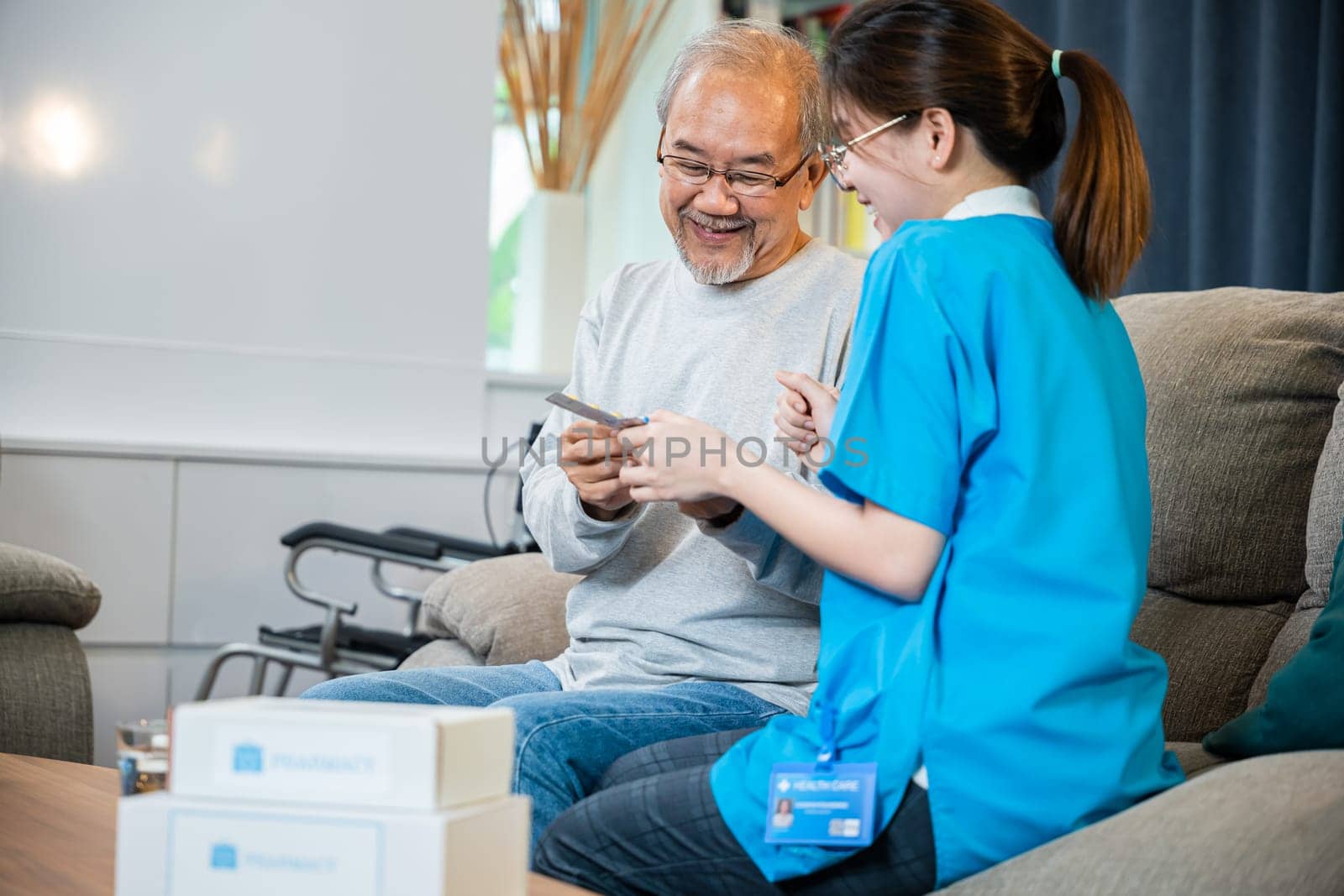 Woman nurse caregiver show prescription drug to senior man at nursing home by Sorapop