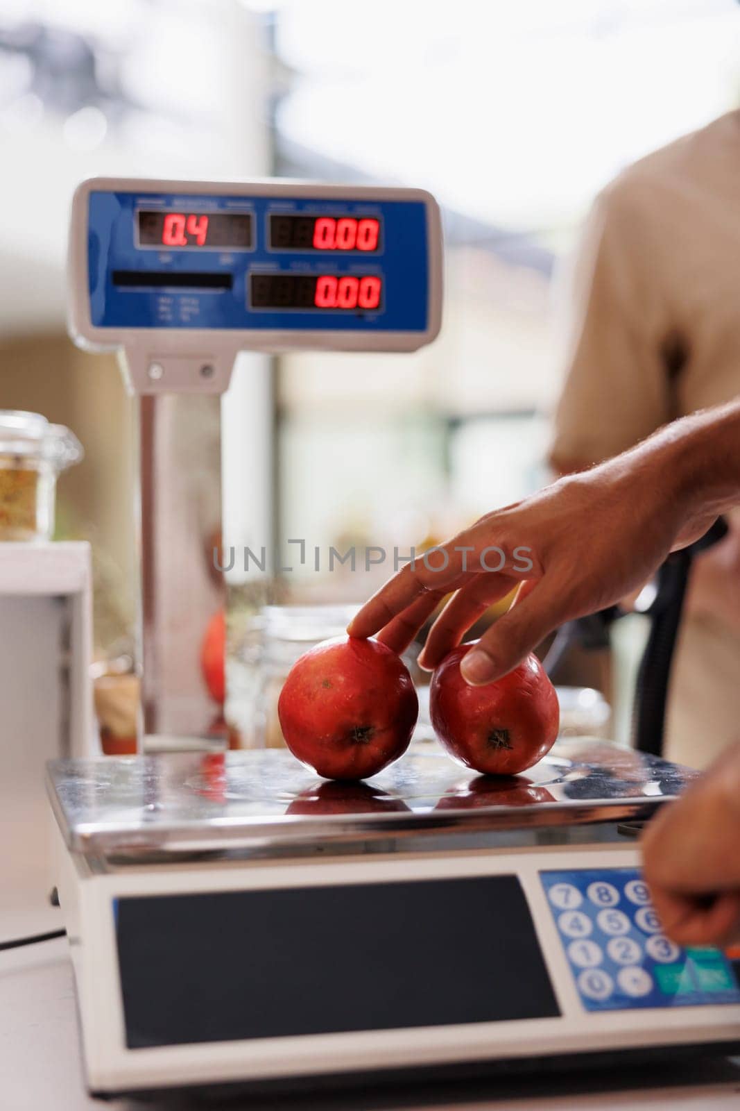Cashier using weighing machine in store by DCStudio