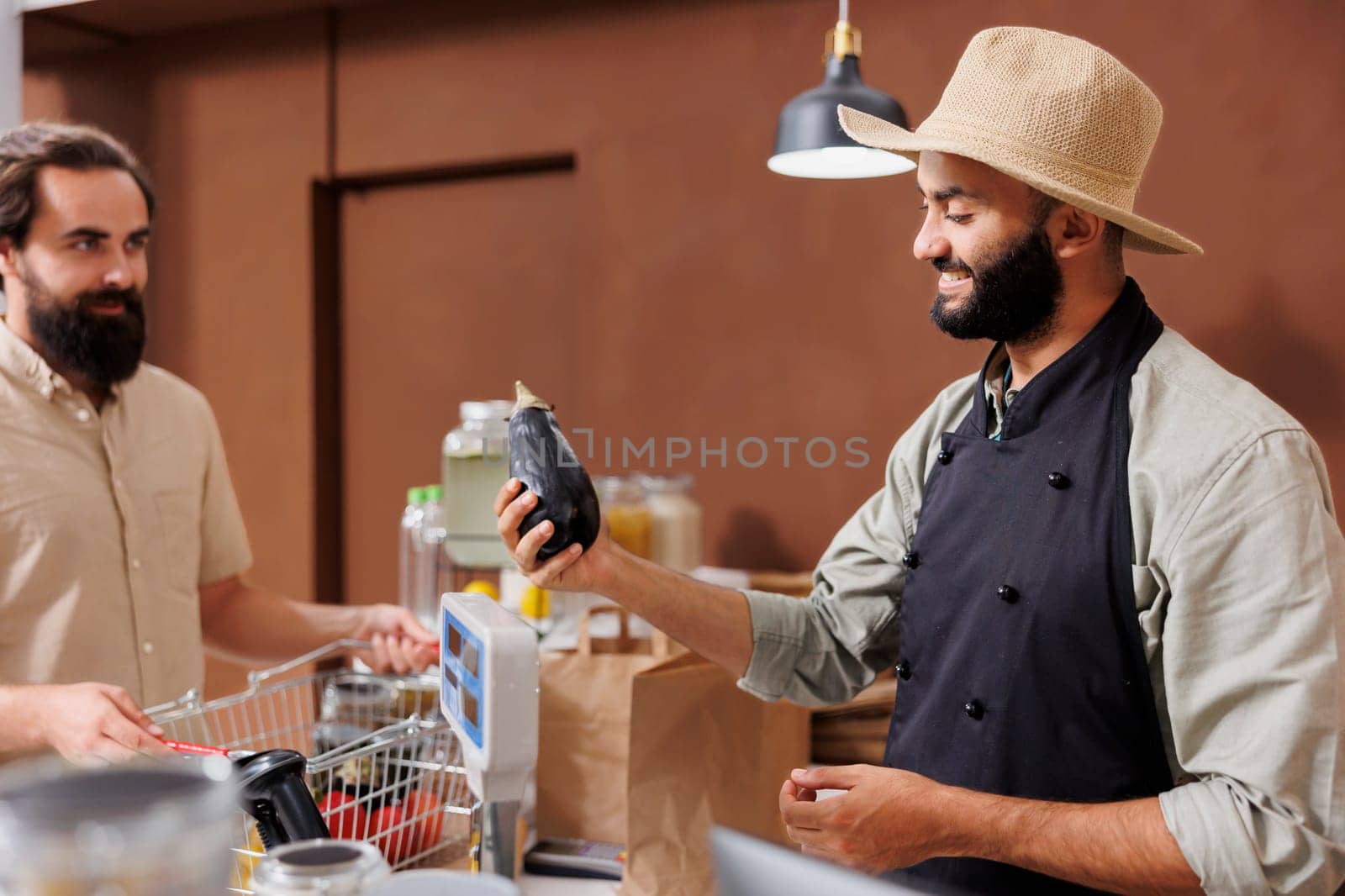 Middle eastern vendor talking to customer and selling homegrown products at local store. Shopkeeper helping client to choose locally grown produce, explaining health benefits of fresh food.