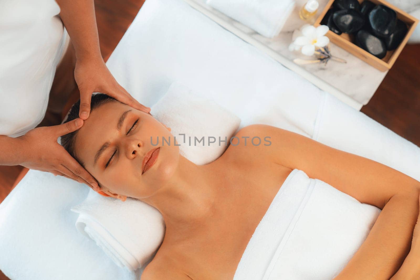 Panorama top view of woman enjoying relaxing anti-stress head massage and pampering facial beauty skin recreation leisure in dayspa modern light ambient at luxury resort or hotel spa salon. Quiescent