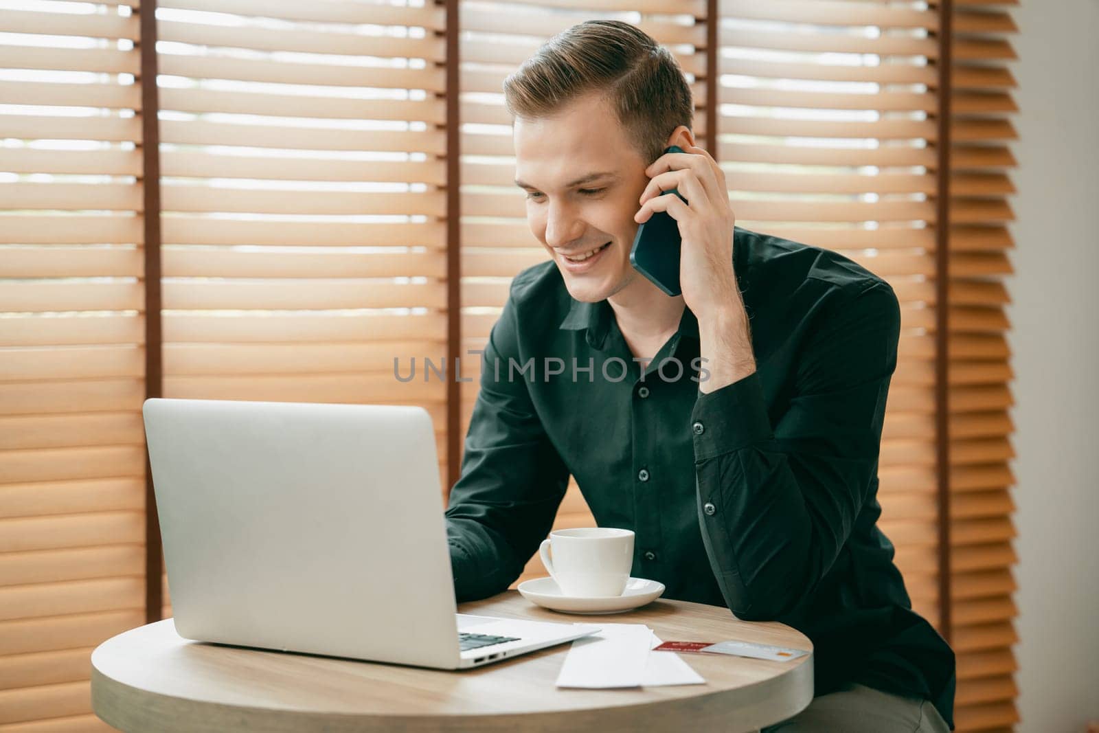 Happy businessman or salesman doing online business, remote working with laptop and making phone calls for sales at home. Telesales and modern business with communication. Unveiling
