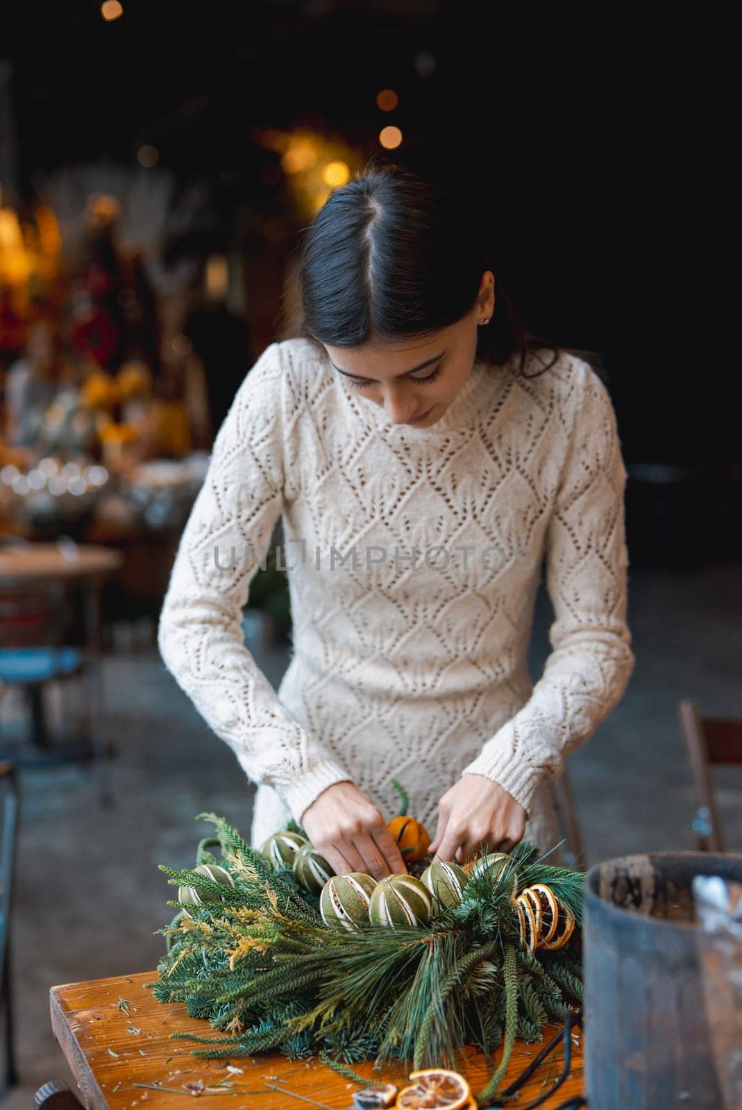 In a crafting masterclass, a young lady learns to make Christmas decorations. High quality photo