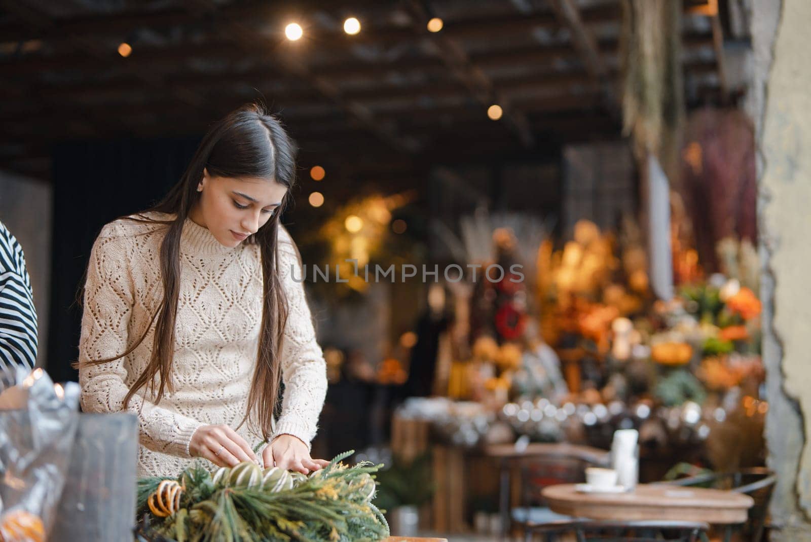 Finishing touches on the Christmas wreath displayed at the flower shop counter. High quality photo