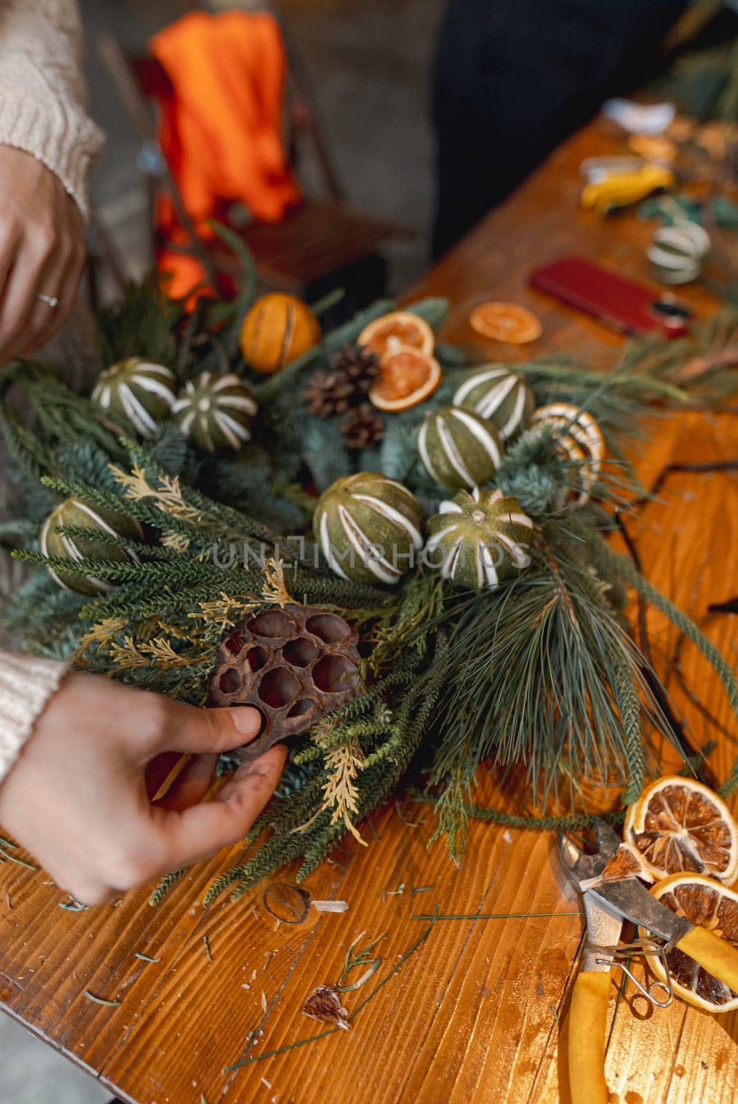 Engaging in a masterclass, a young lady creates Christmas decorations. High quality photo