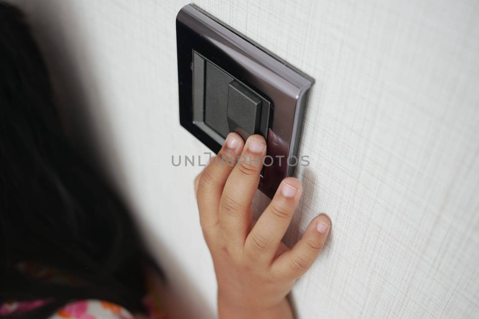 child finger turning on lighting switch with copyspace by towfiq007