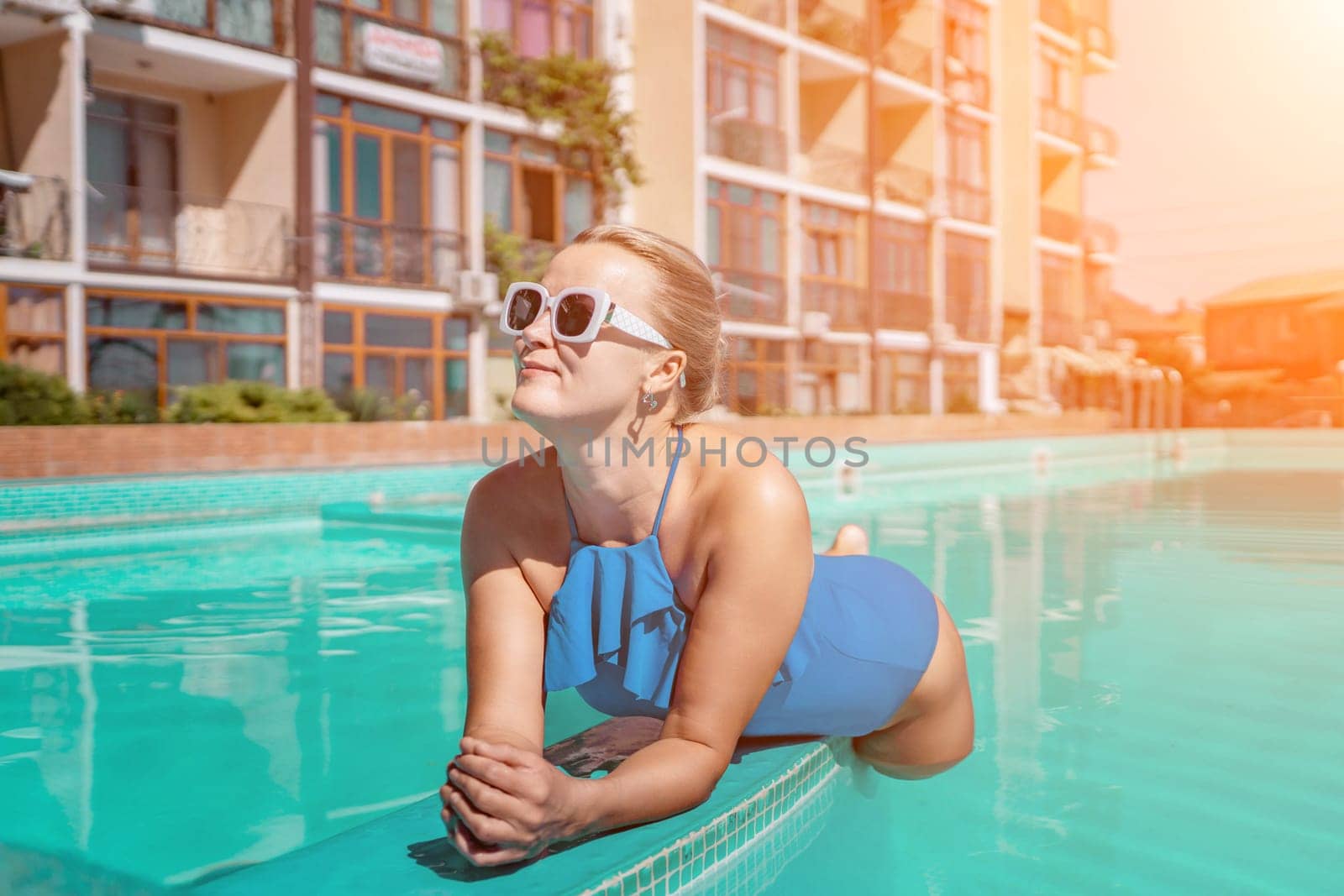 Bikini-clad woman enjoys poolside relaxation. Poolside ambiance. Capturing woman's relaxed time near pool. by Matiunina