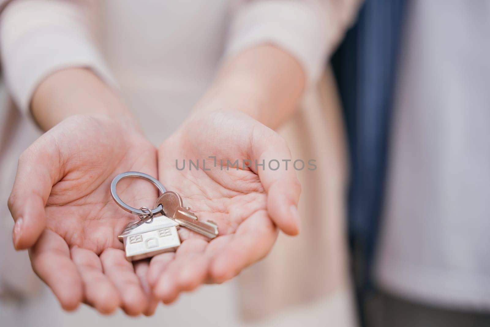 Landlord's hand presents keys for a new house. Symbolizes investment tenant security and real estate ownership. Close-up view denotes successful property deal. Give me the keys