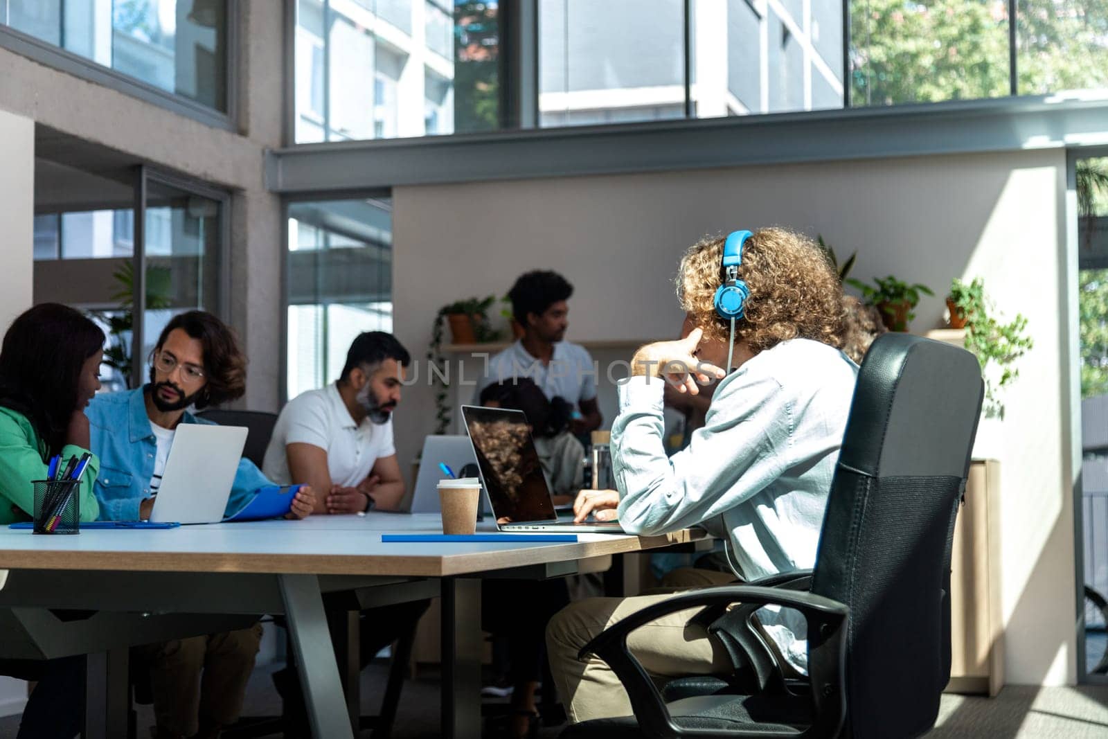 Group of multiracial coworkers working in bright coworking space. Copy space. Business concept.