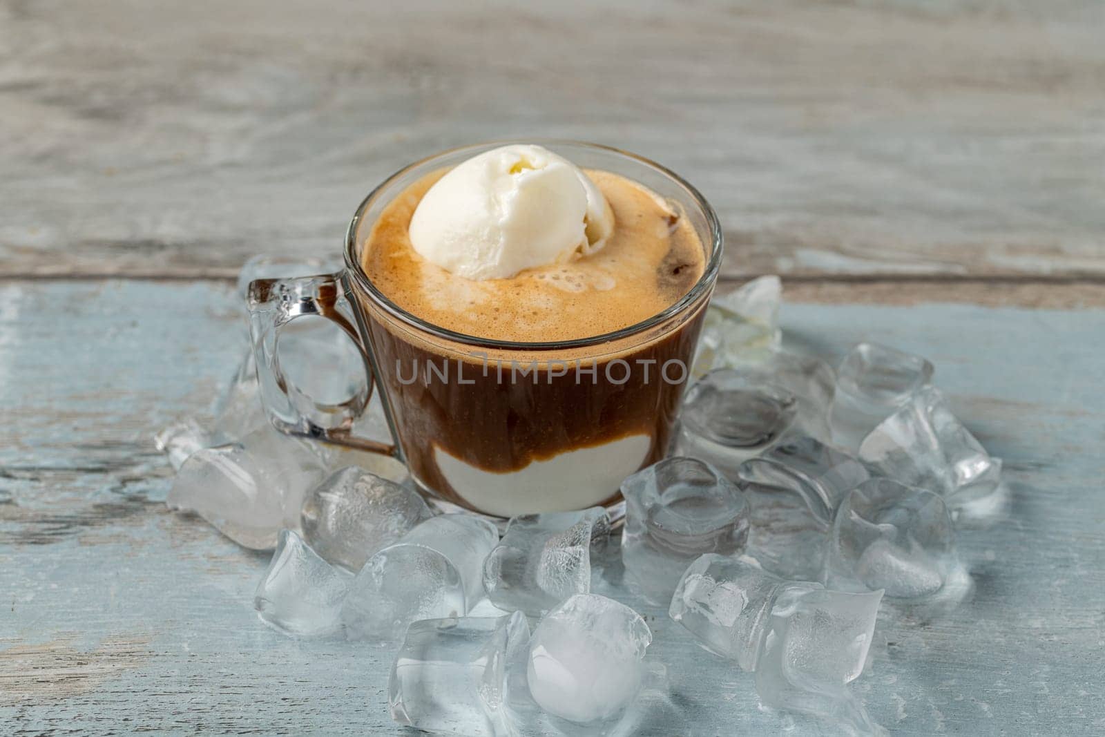 Affogato coffee with vanilla ice cream in a glass cup on wooden table