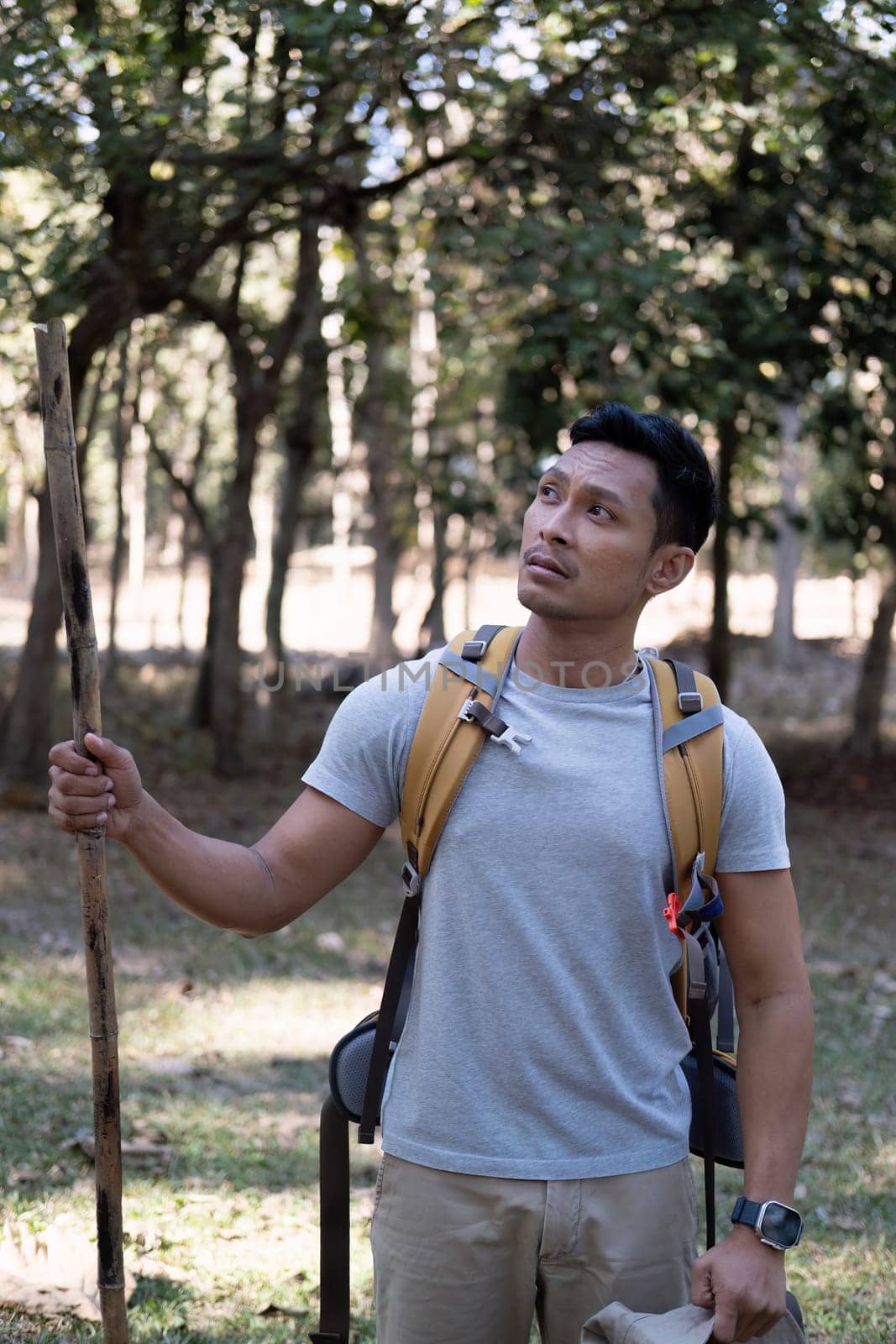 Portrait of a happy smiling Asian tourist, 30-35 years old, backpacking in a national park. asian male tourist enjoying his hiking trip Nature activities, holidays, outdoor hobbies..