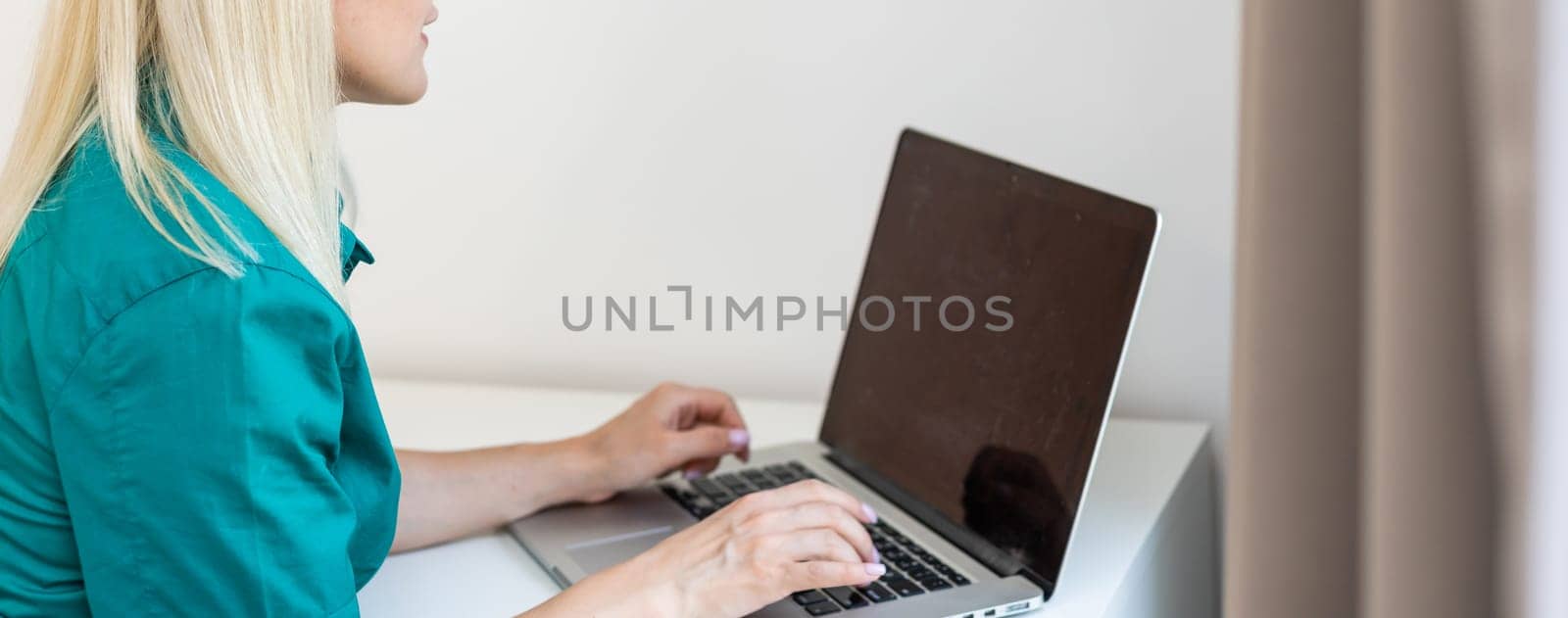 young beautiful woman using a laptop computer at home by Andelov13