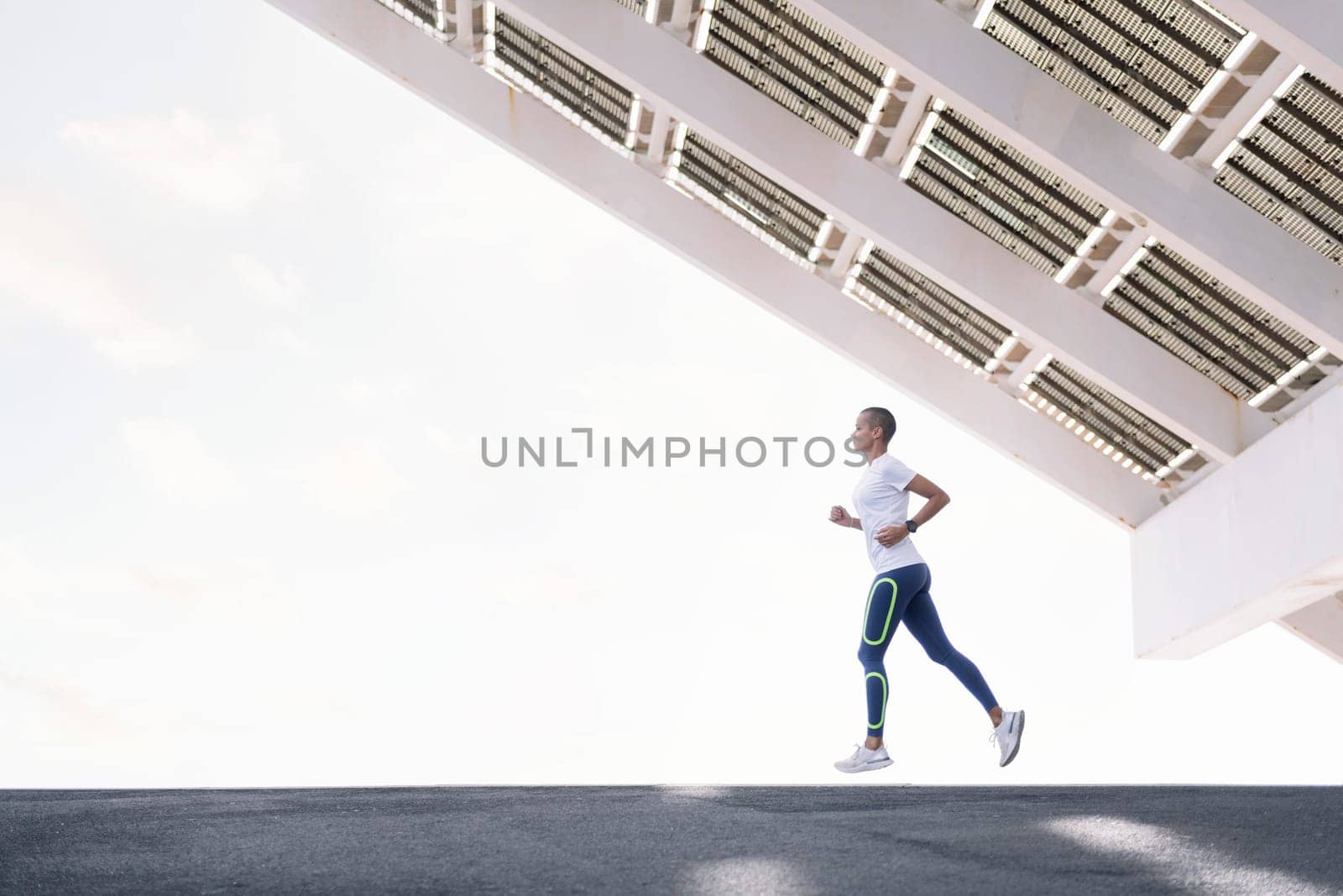 young sporty woman with short hair practicing running, concept of active and healthy lifestyle, copy space for text