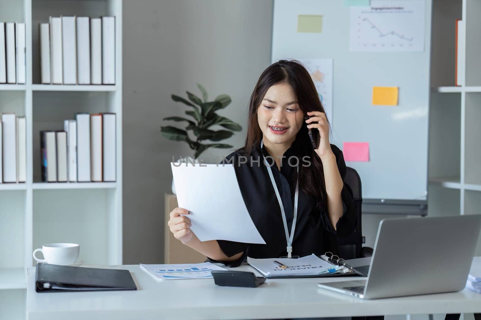 Businesswoman on the phone and using laptop at office. Businesswoman professional talking on mobile phone.