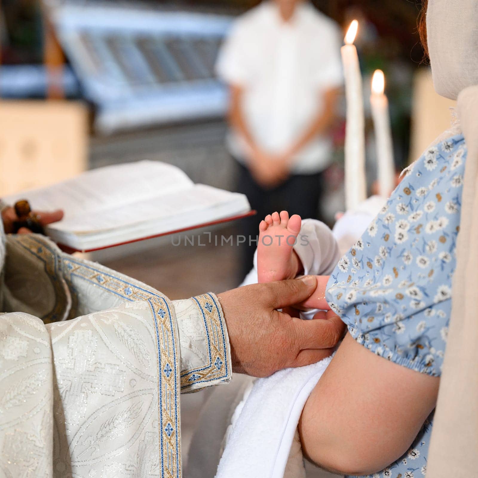 The priest performs the rite of baptism of the child and anoints the leg with holy myrrh, the sacrament of Christian baptism.