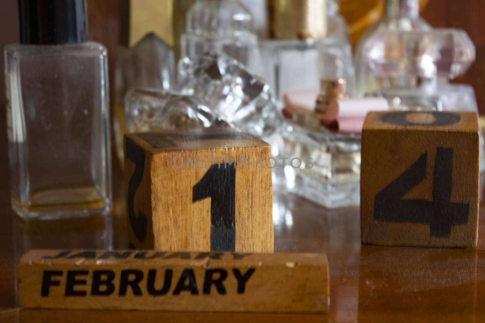 Valentine's Day represented through wooden cubes among perfume bottles