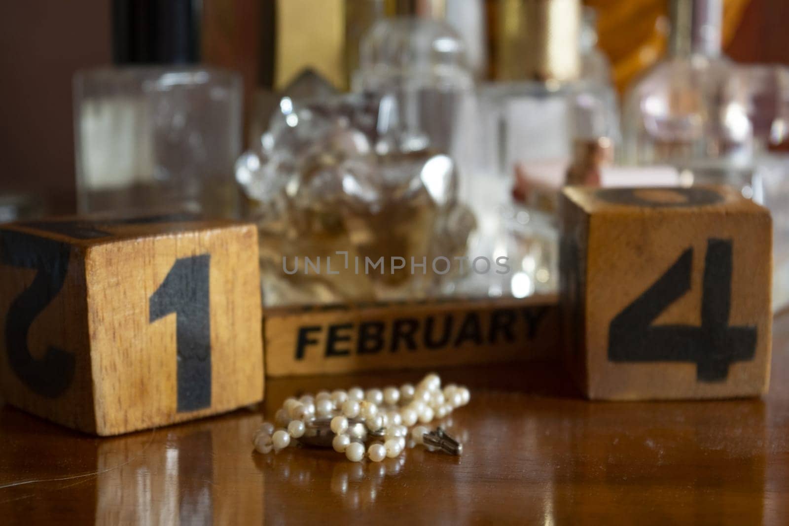 Valentine's Day represented through wooden cubes among perfume bottles