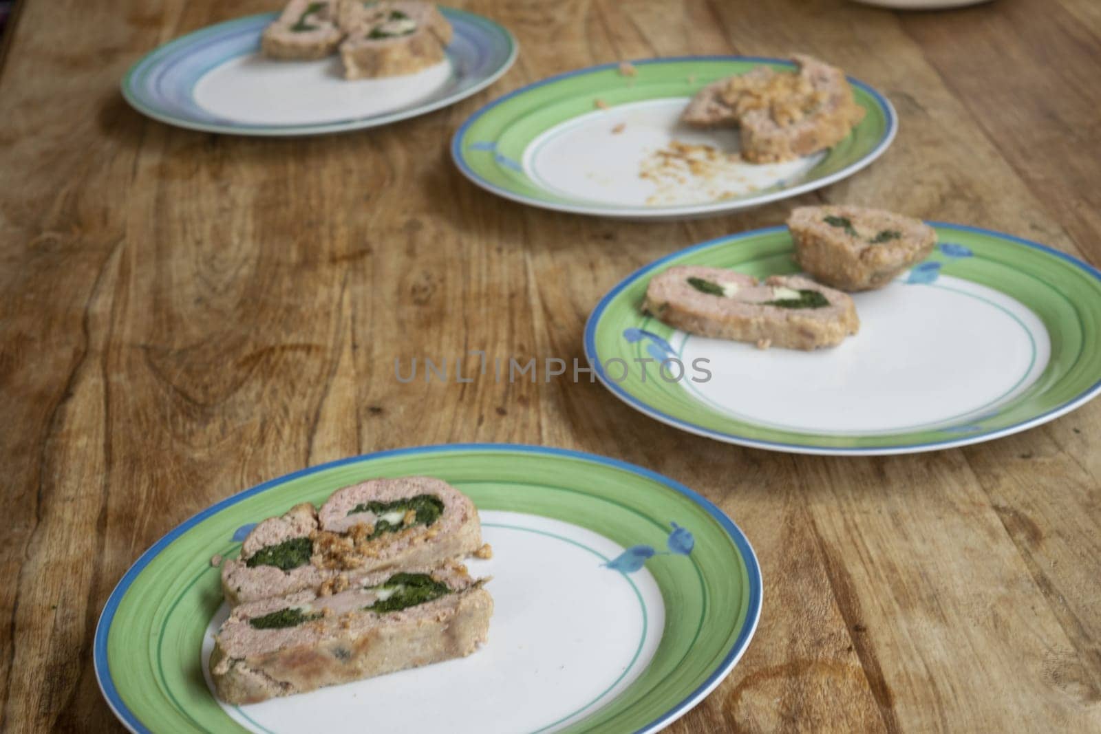 slices of spinach-filled meatloaf lined up in an white dish