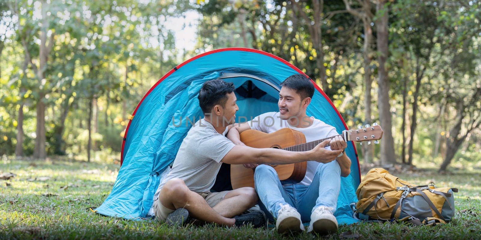 Male gay couple asian traveling with tent camping outdoor and various adventure lifestyle hiking active summer vacation.