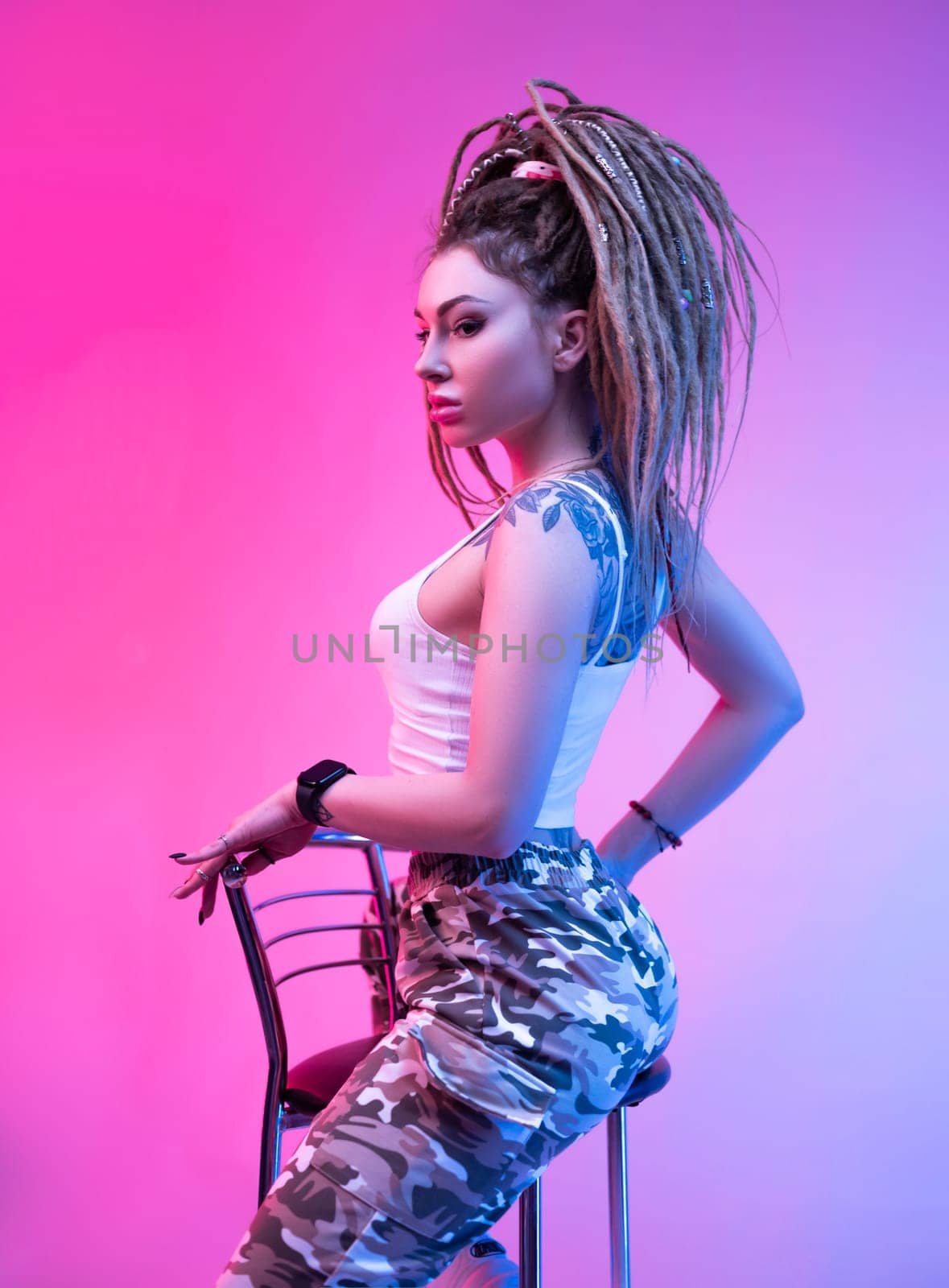 cool girl with braided dreadlocks on her head in neon light on a light background by Rotozey