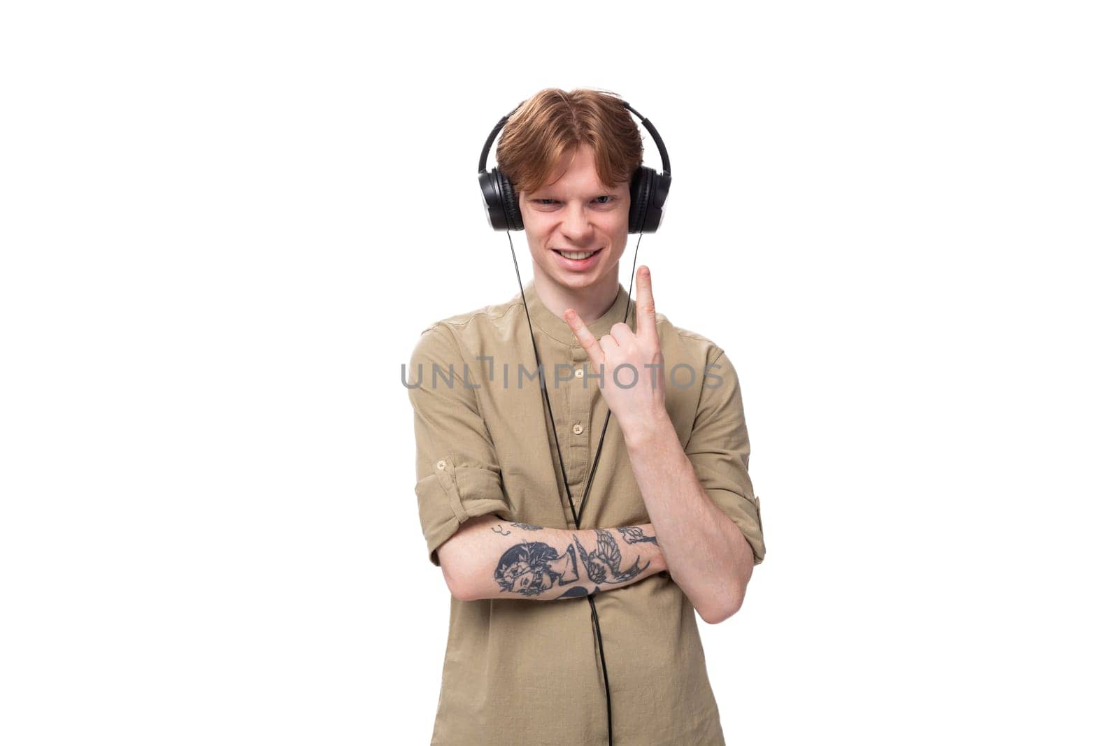 young handsome redhead man in glasses and shirt enjoying playlist in headphones.