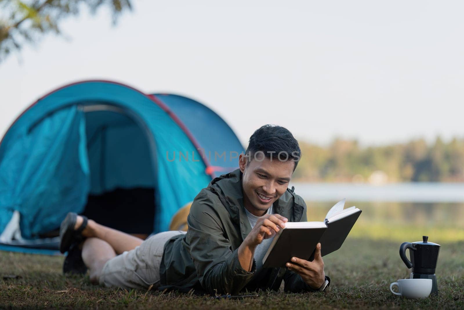 Man read book while traveler with camping. Concept of modern people lifestyle in working.