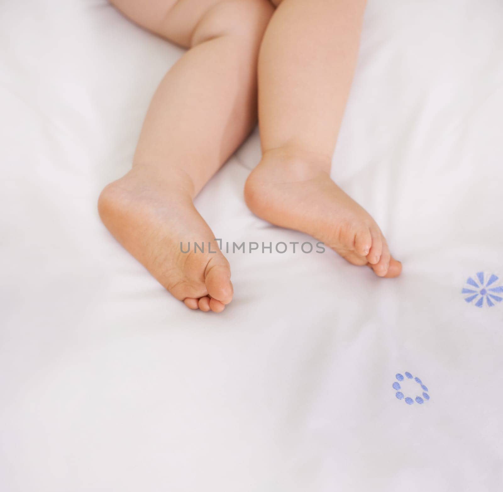 Baby sleeping, feet and top view on bed to relax, comfort and calm at home on mockup space. Toddler, above and closeup of cute foot, legs of adorable child and young kid resting in peace in bedroom by YuriArcurs