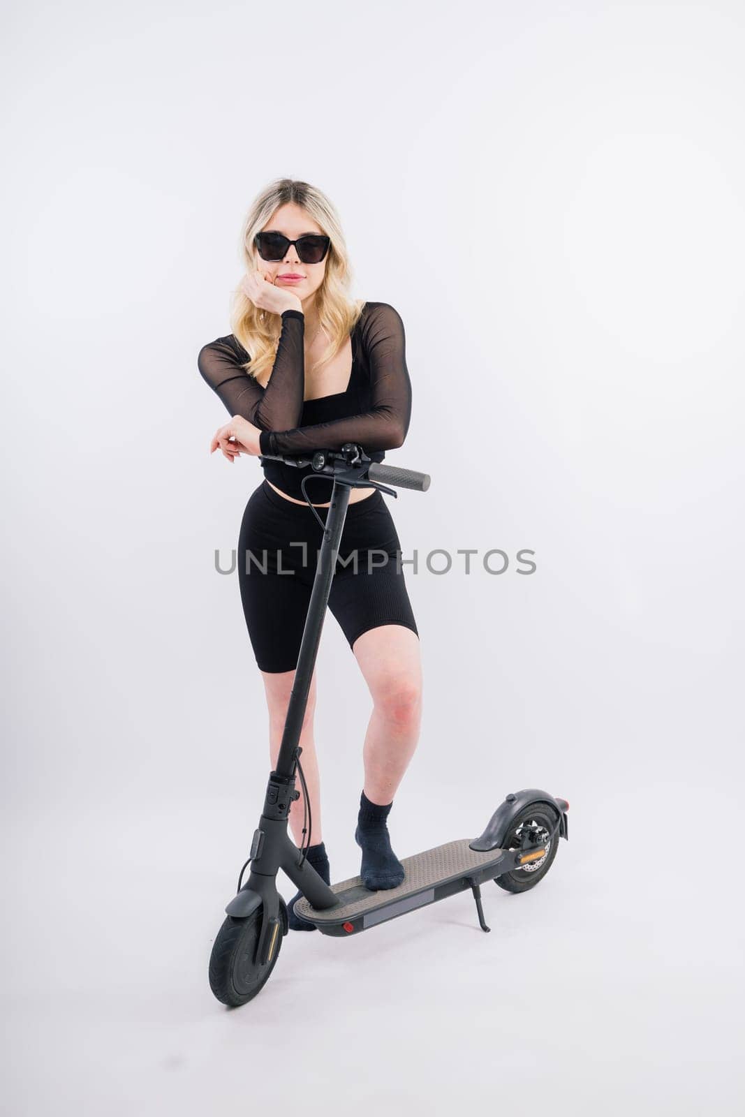 Female in sport clothes stands on electric scooter with sunglasses on red and white background by Zelenin