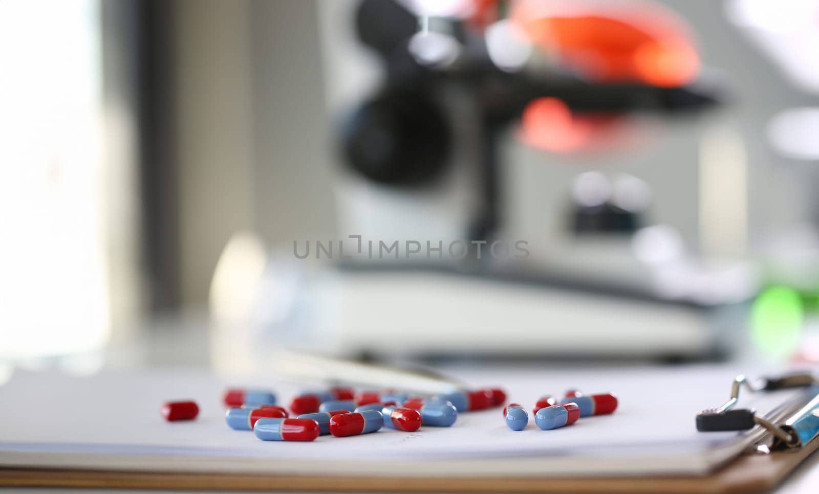 Tablets scattered blue and red color on the table of pharmaceutical laboratory pill for the prescription and treatment various diseases chemistry