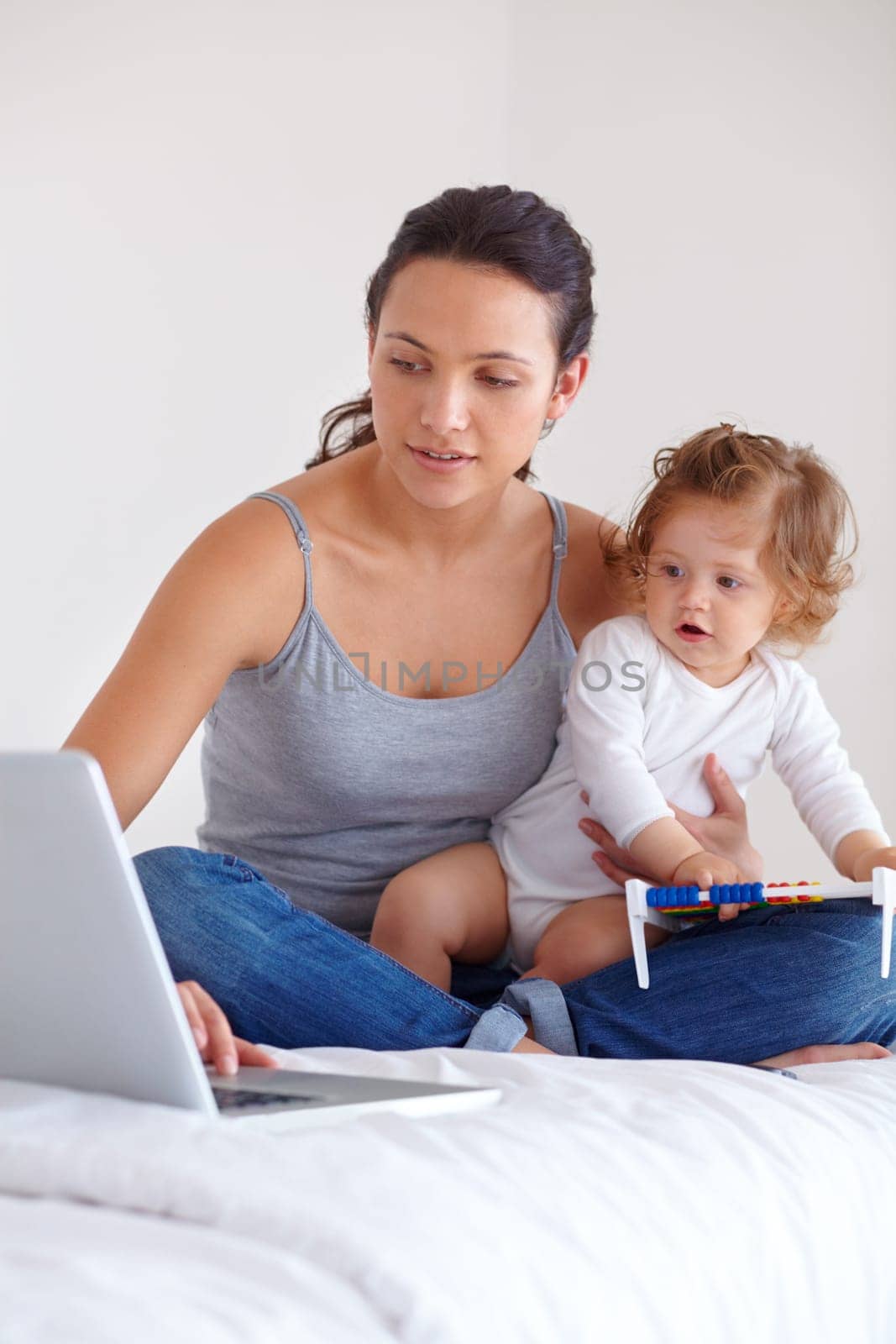 Laptop, baby and mom in bedroom for remote work, mom learning or online education in home. Freelancer parent, computer and kid on bed playing with abacus, child care and toddler together with family by YuriArcurs