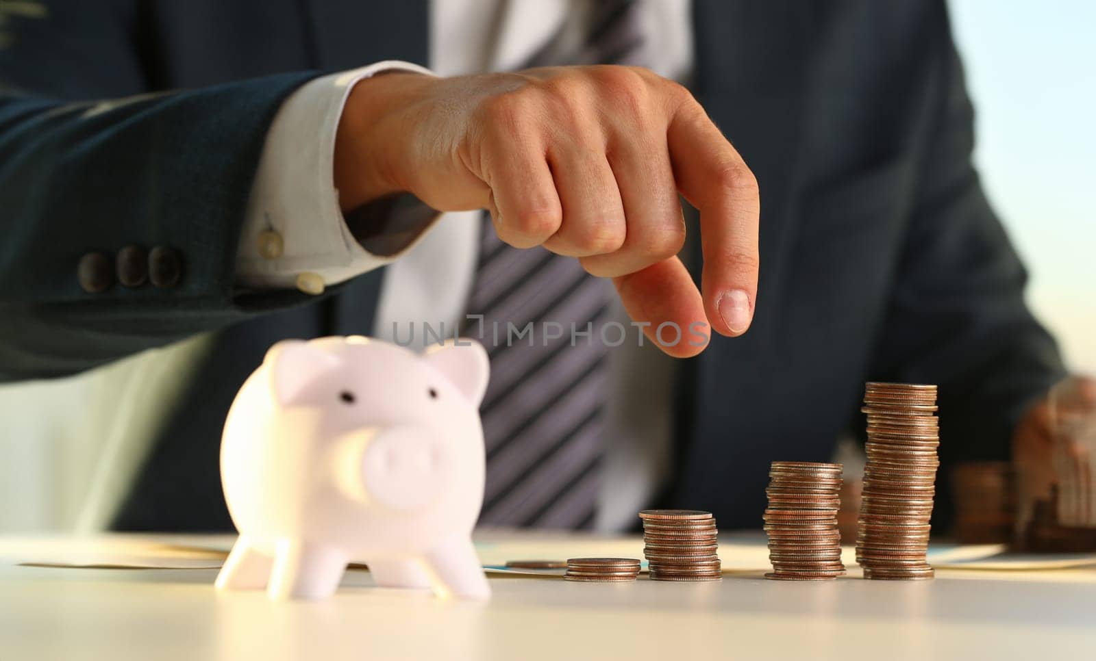 Hand businessman putting pin money into pig. Future needs loan education or mortgage credit spend vacation of dream effective buying financial risk and safety concept
