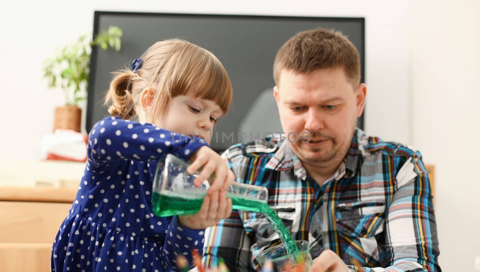 Man and little girl play with colourful liquids portrait. Young team clean research equipment colour reagent food additions flavor activity flavour concept