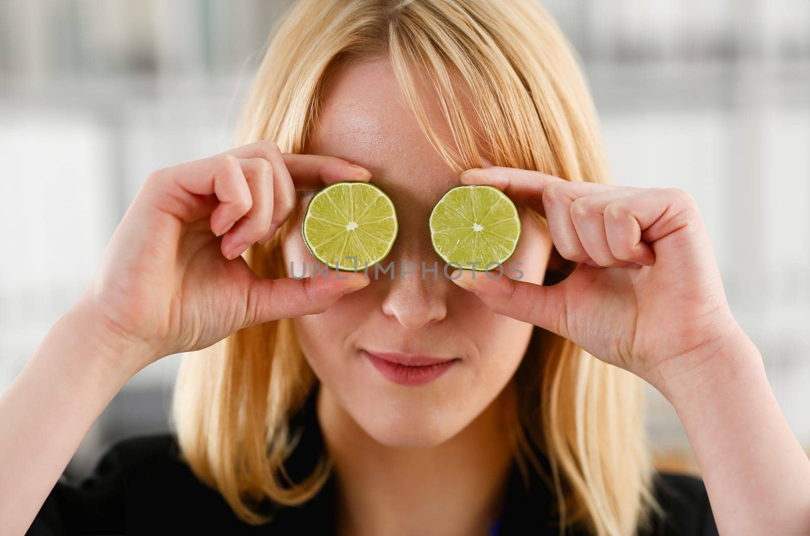 Female hands hold a cut fruit at eye level instead of glasses. The theme of a healthy diet for withdrawal activities and belief in diet achievements in business and education.