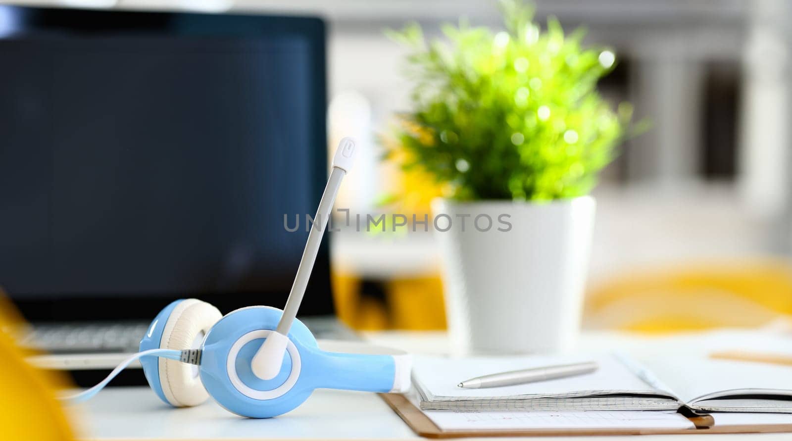 Empty remote office workplace with laptop pc and headset closeup. Receptionist or secretary of contact data center desktop keyboard device desk table ip telephony or callcenter voice message system