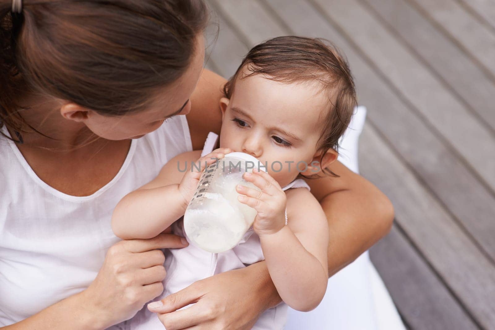 Baby, mother and drinking formula for nutrition, food and relaxing together on porch at home. Mommy, toddler and bottle for health or child development in outdoors, feeding and milk for wellness.