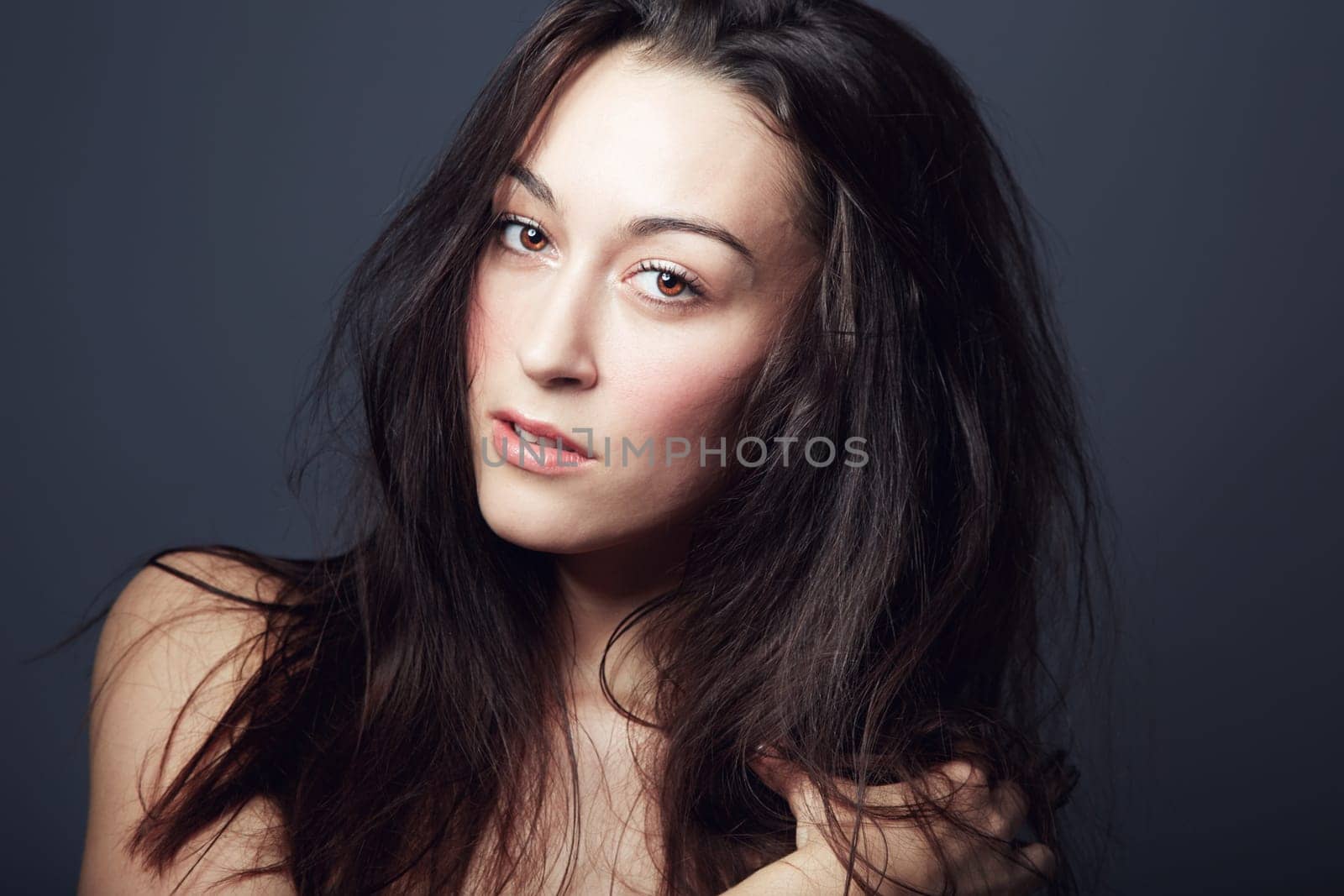 Beauty, cosmetics and face of woman with hair in studio, hairstyle and shine isolated on dark background. Portrait, makeup glow on skin with dermatology, haircare and texture with growth and model.