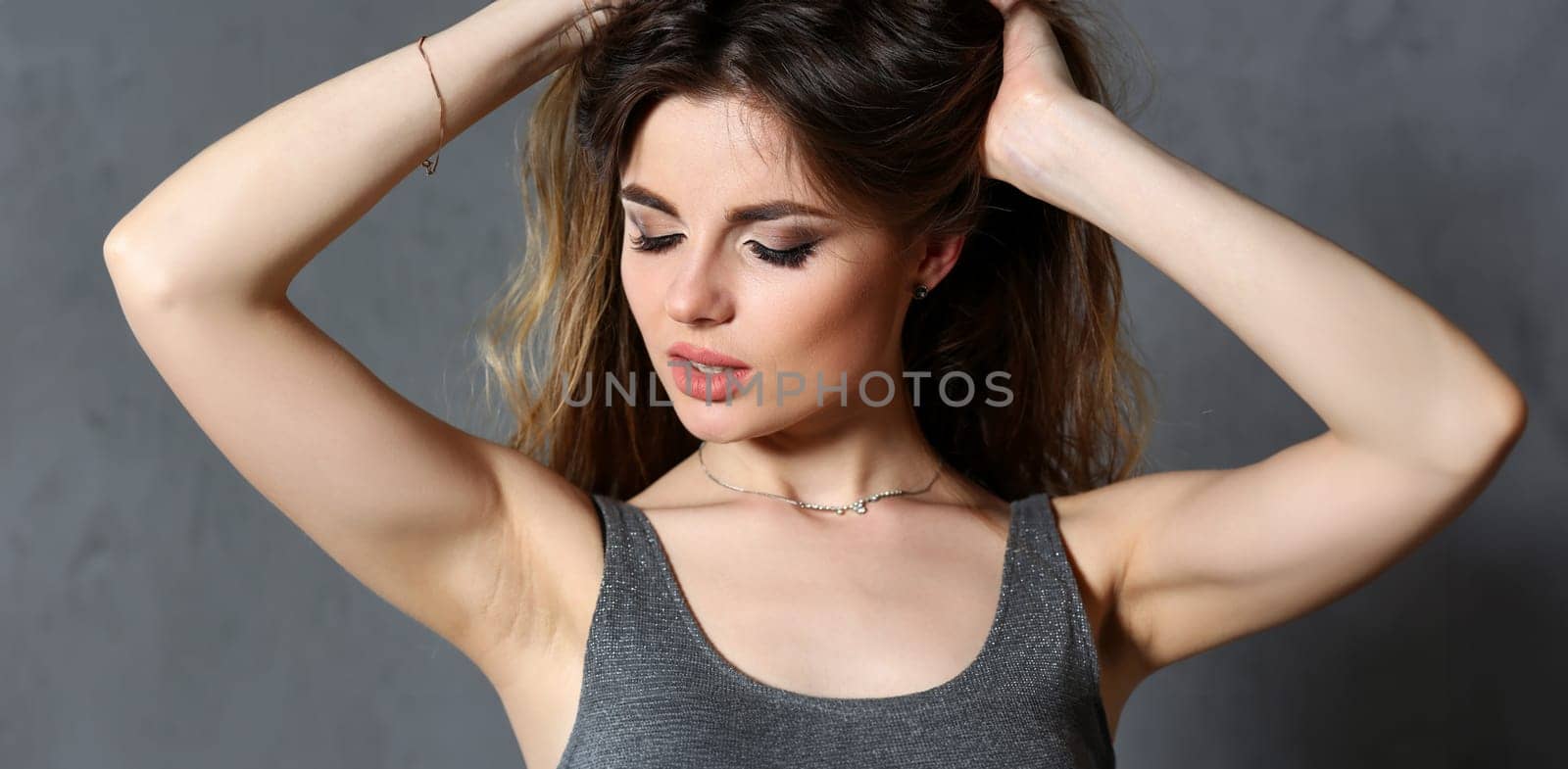 Beautiful european woman portrait. Worth a gray background and smiling beauty fashion style curly hair with white strands view of the eye in the camera