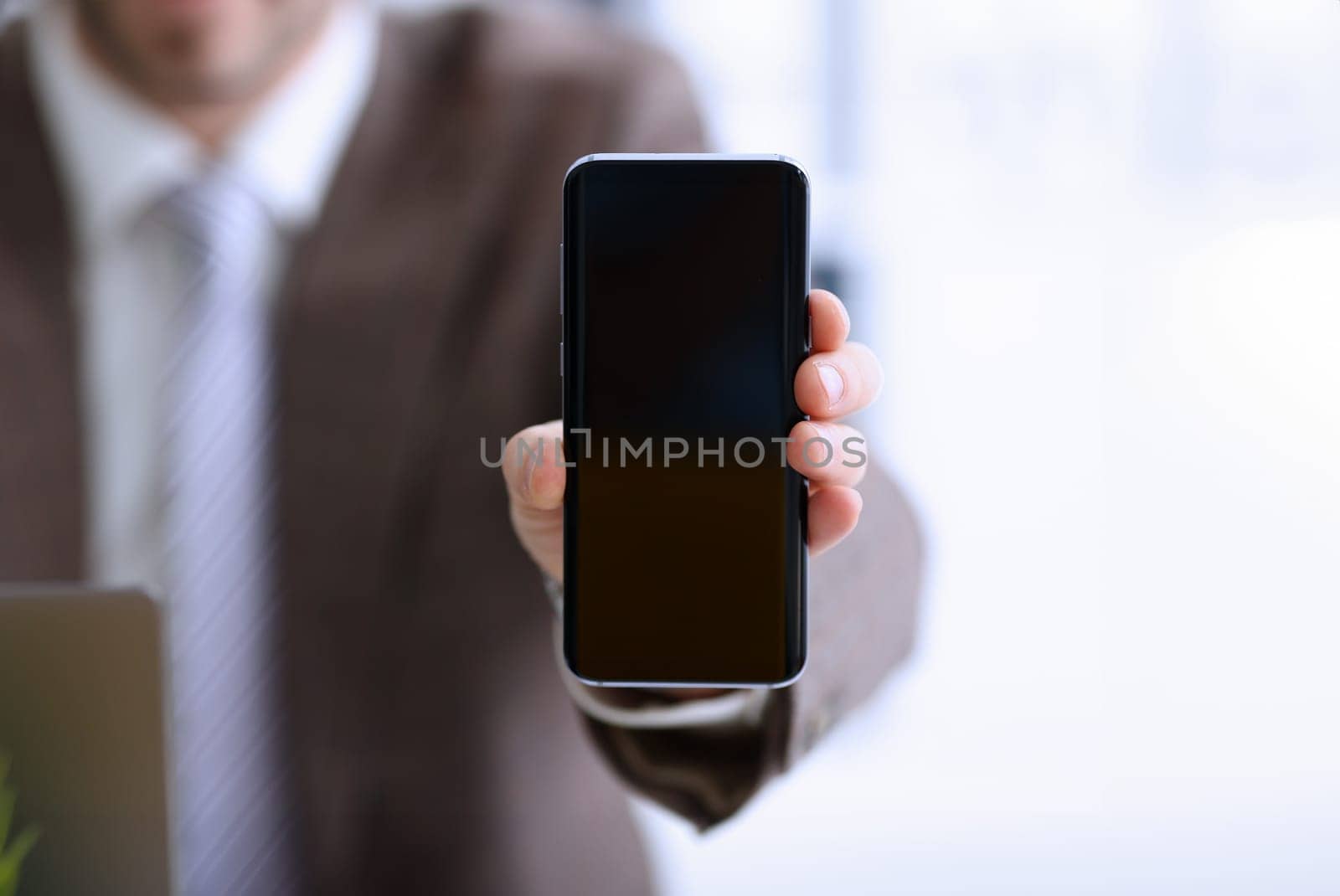 Male arm in suit show in camera phone display screen closeup. Read news mania send sms chat addict use electronic bank modern lifestyle job plan colleague share blog tweet web application search