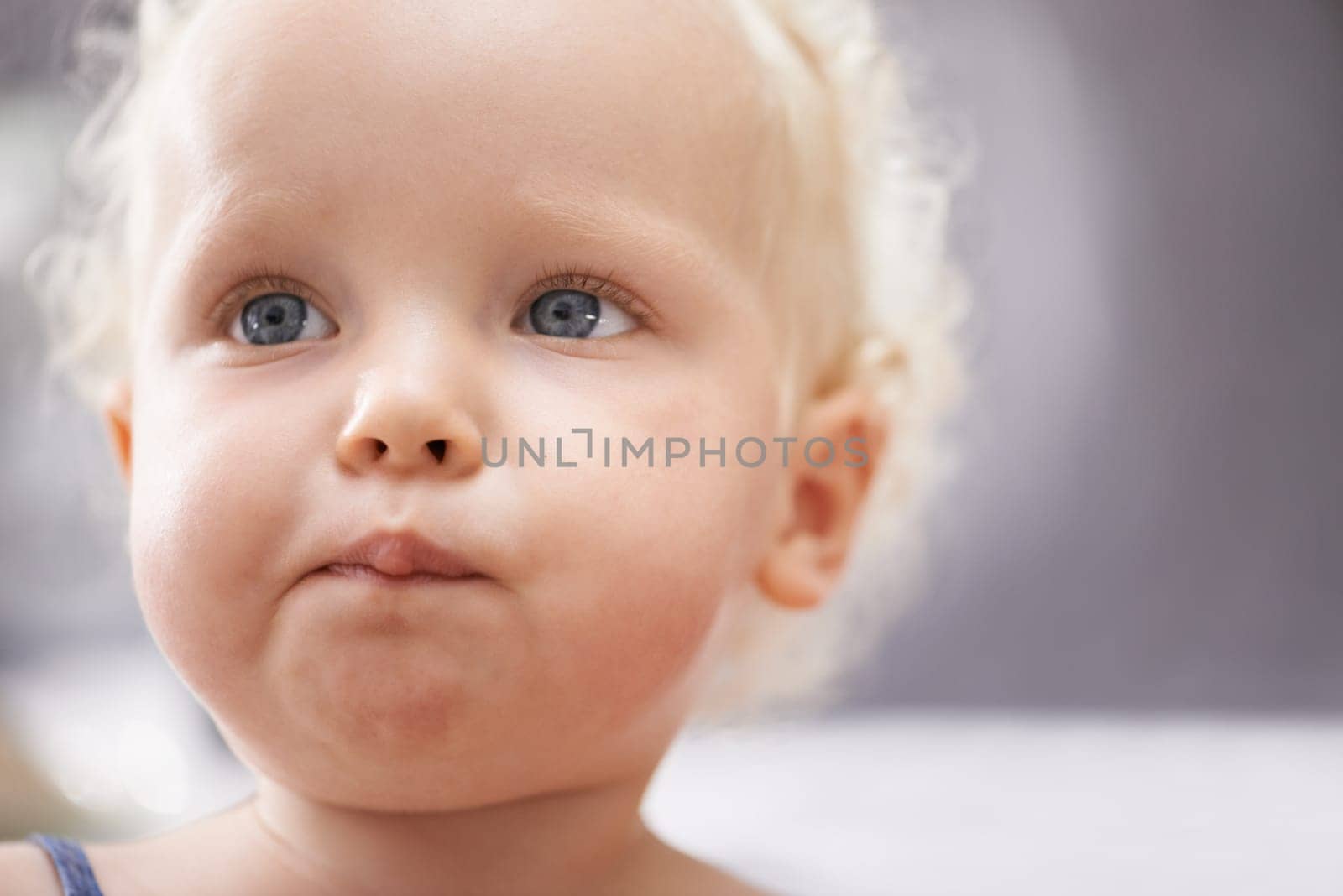 Thinking, baby and face of child in home alone, healthy and adorable in kindergarten or nursery. Dream, cute blonde toddler and young innocent kid, curious and serious facial expression in house by YuriArcurs